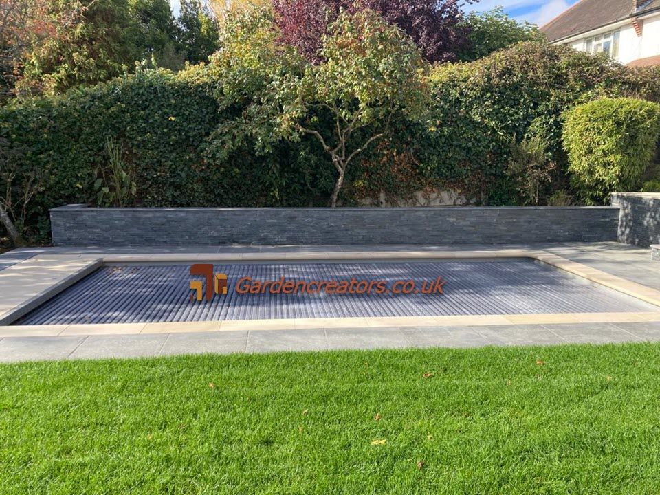 A large swimming pool is sitting in the middle of a lush green lawn.