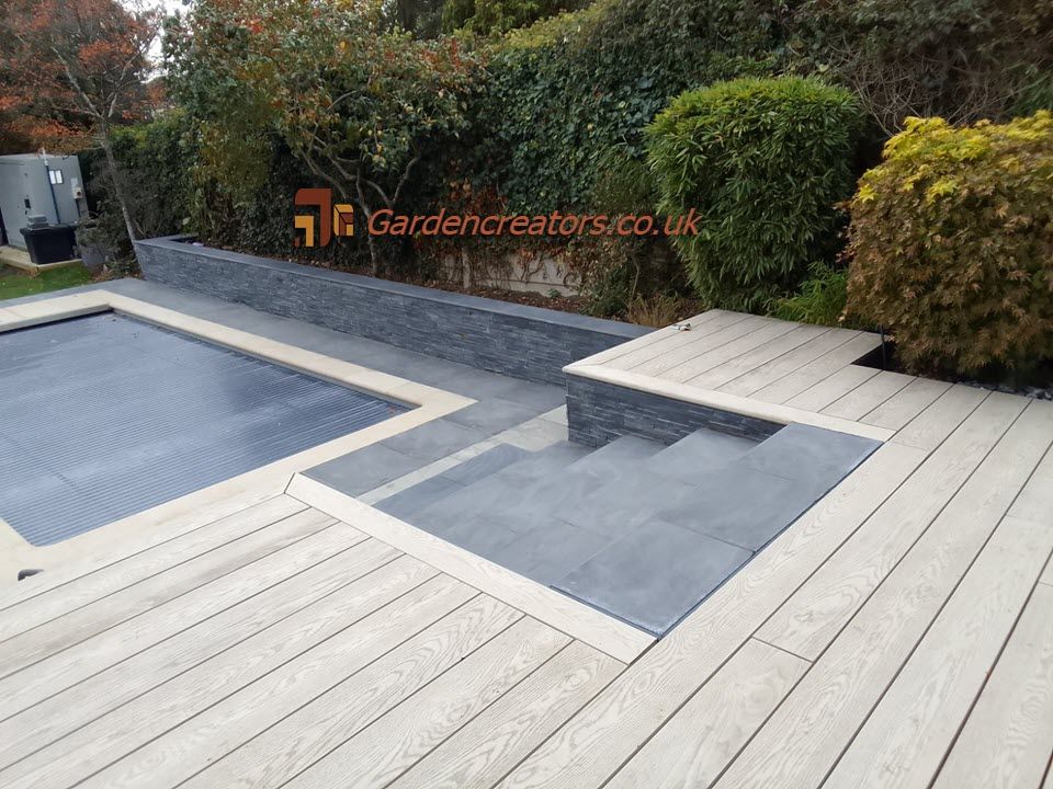 A wooden deck with stairs leading to a swimming pool.
