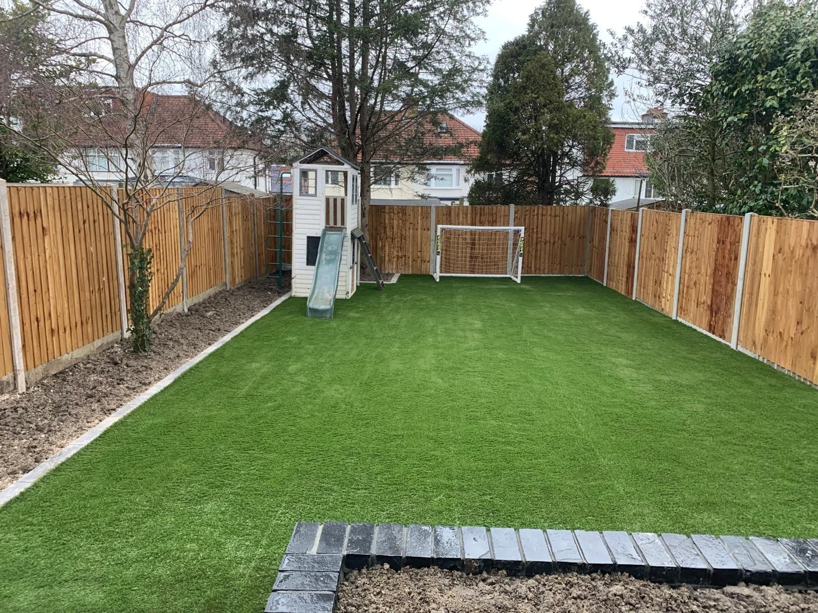 Stone steps leading up to a wooden door, next to a red brick wall and white building.