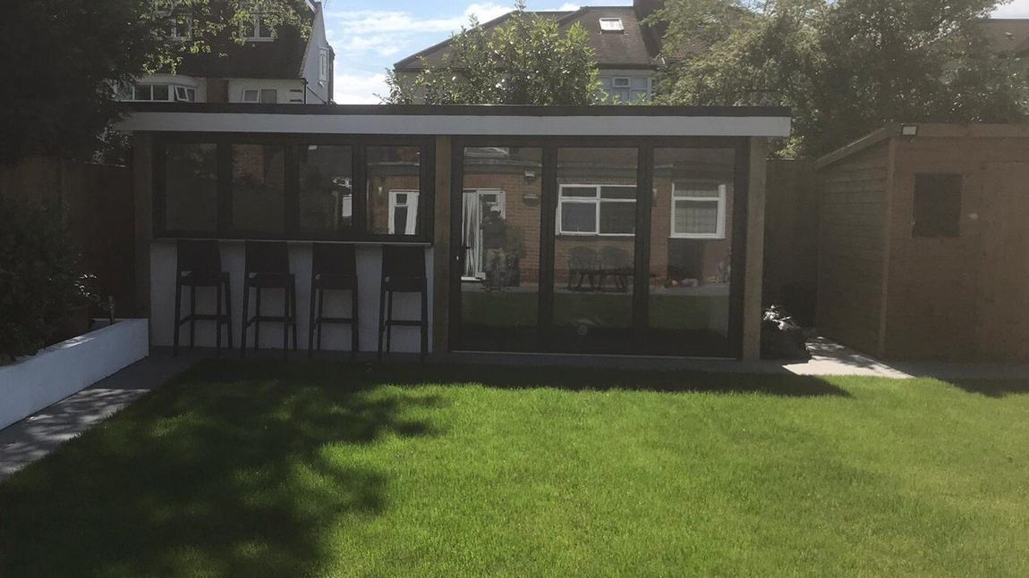 Completed outdoor kitchen bar with bifold windows & door for all seasons