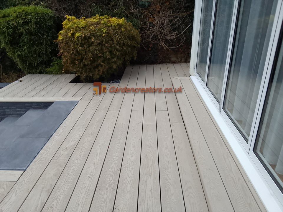 A wooden deck with a sliding glass door in the background