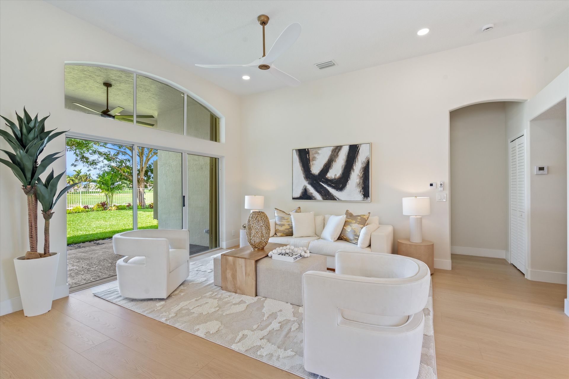 A living room with a couch , chairs , and a ceiling fan.