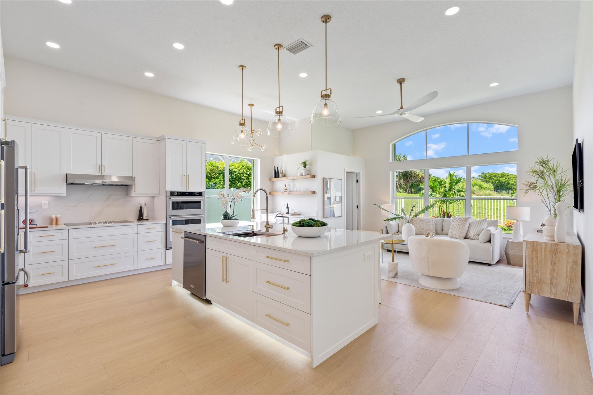 A kitchen with white cabinets and a large island in the middle of the room.