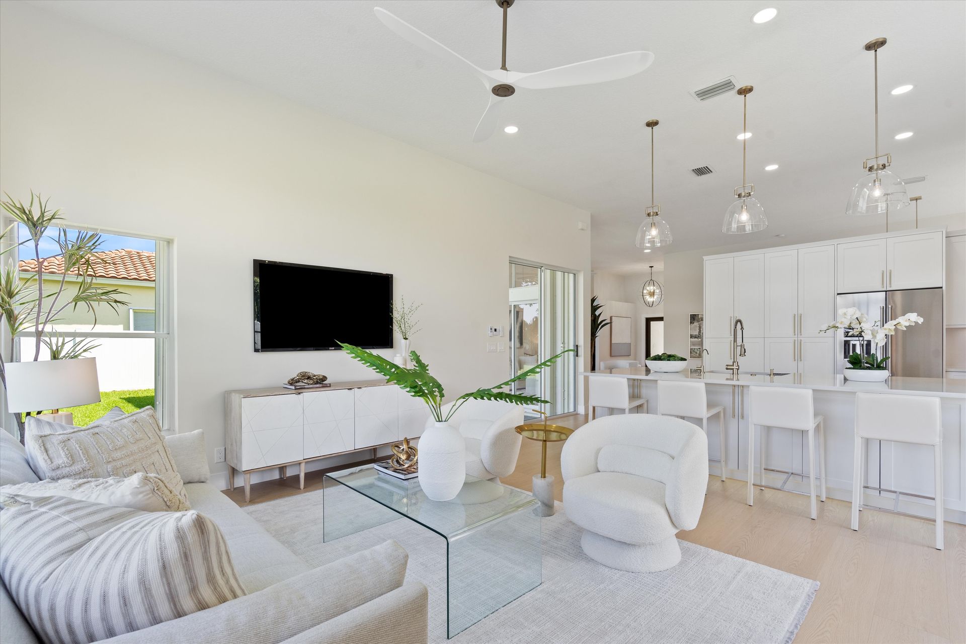 A living room with white furniture and a flat screen tv
