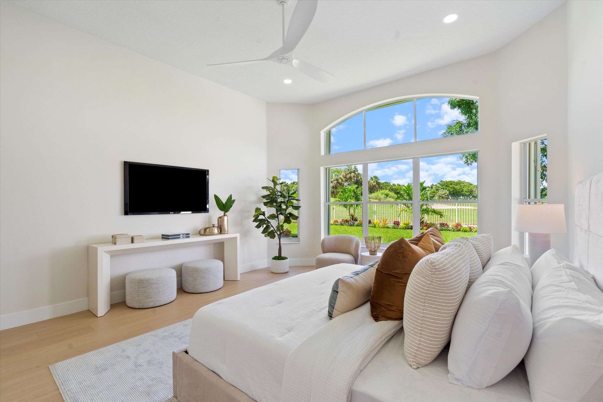 A bedroom with a large bed and a flat screen tv on the wall.