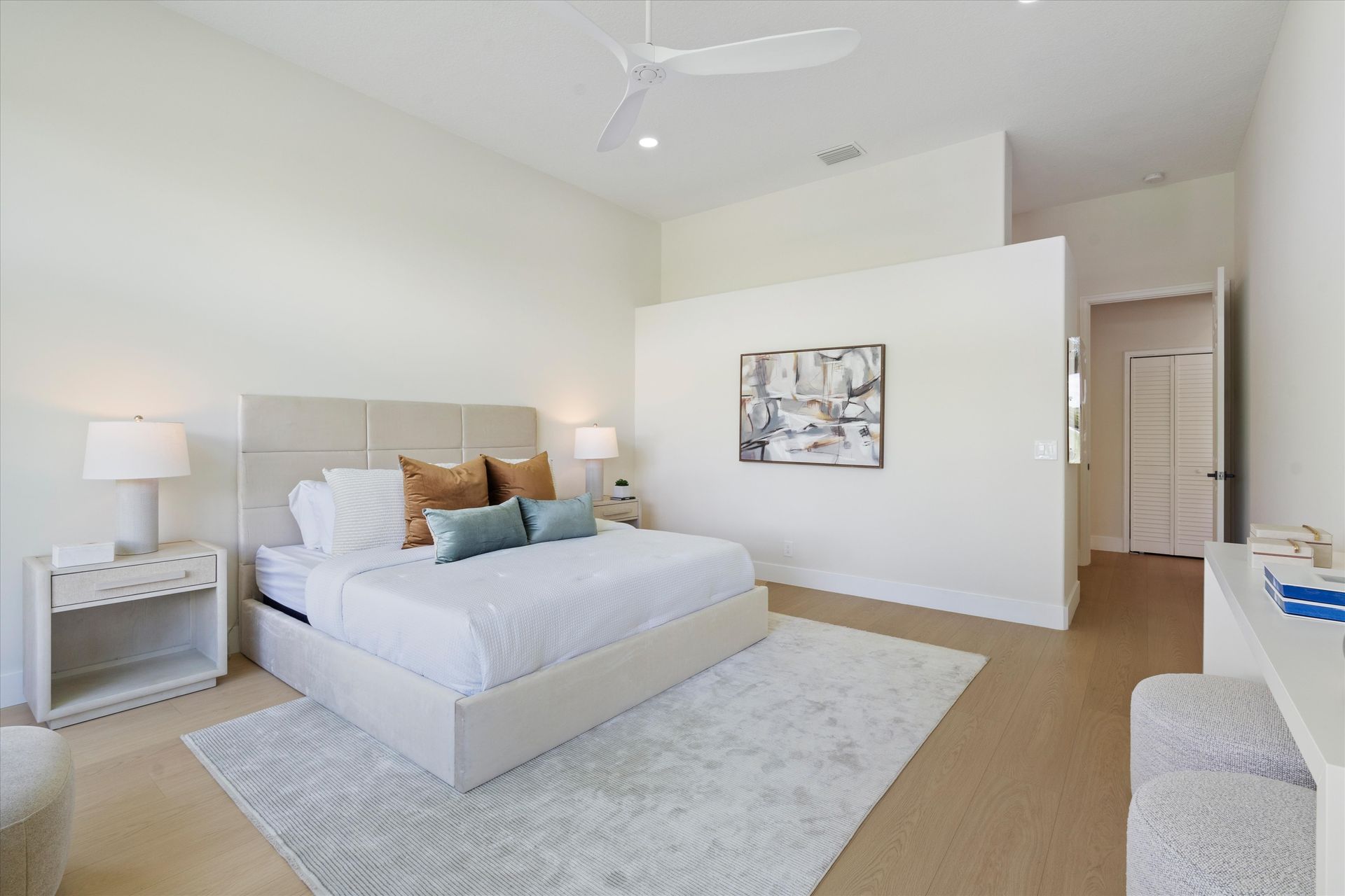 A bedroom with a large bed and a ceiling fan.
