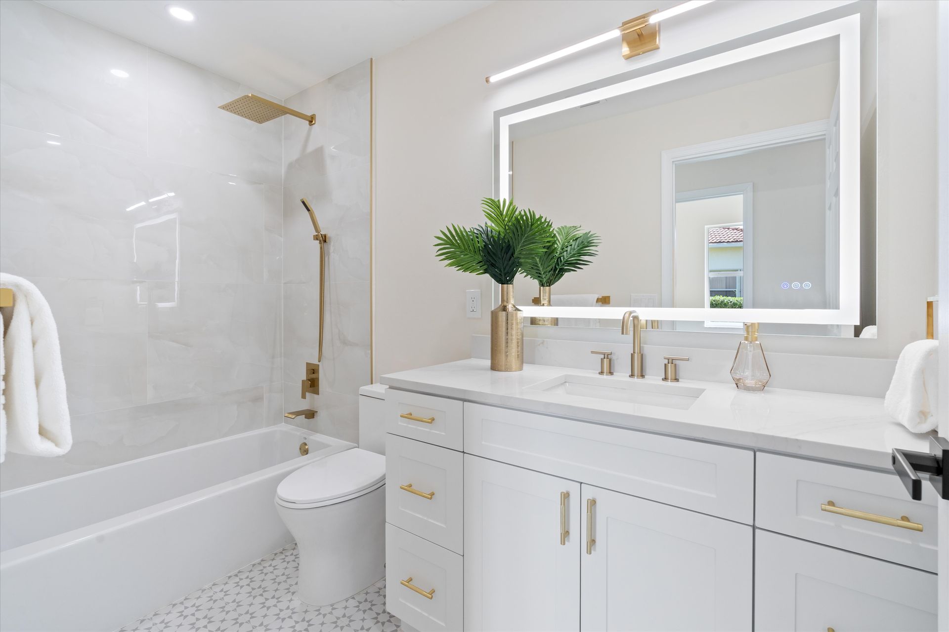 A bathroom with a sink , toilet , bathtub and mirror.