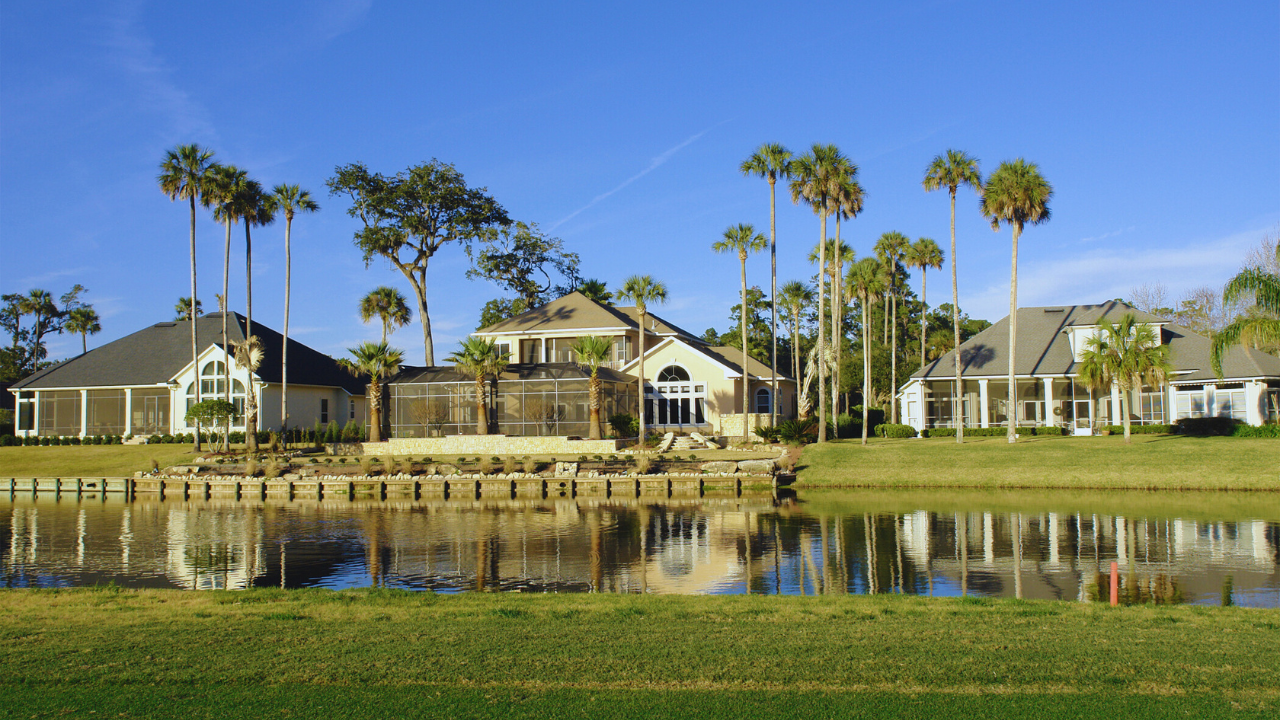 A row of houses next to a lake with palm trees