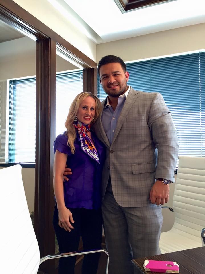 A man and a woman are posing for a picture in an office.
