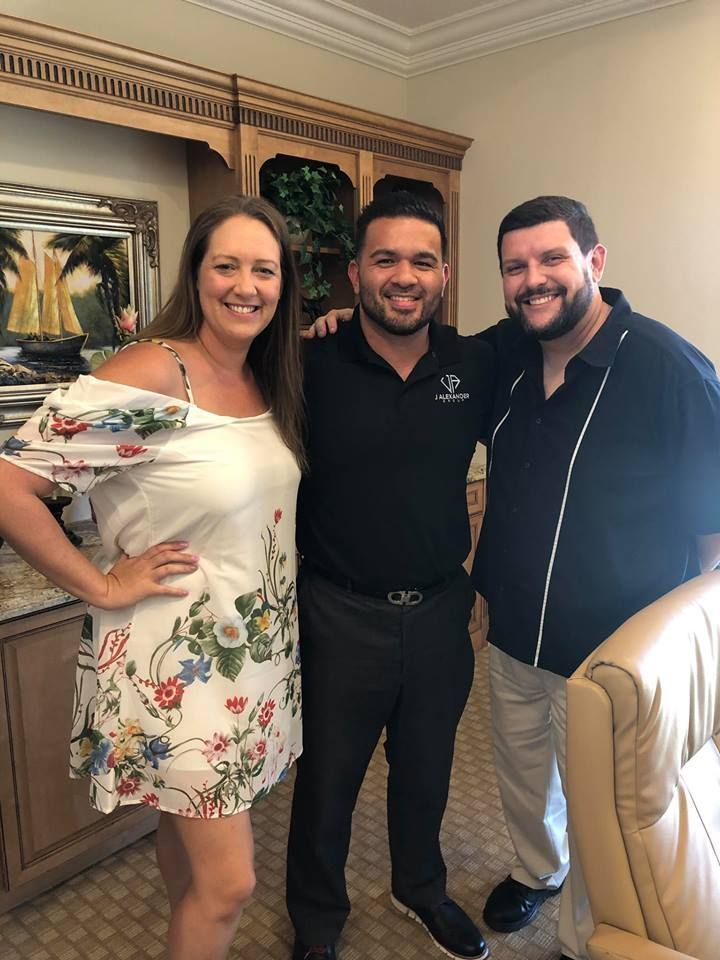 Three people are posing for a picture in a living room.