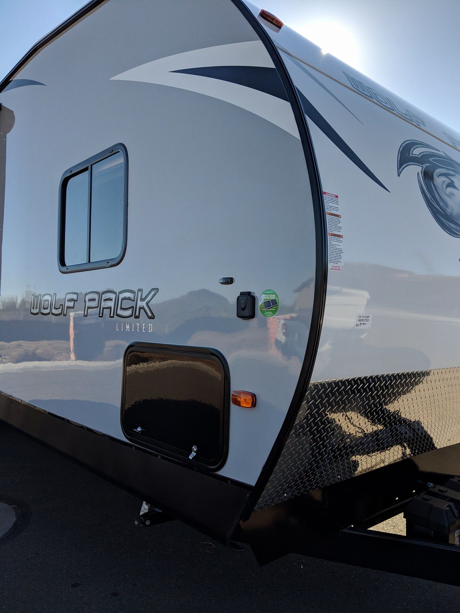 A wolfpack trailer is parked on the side of the road with Bob Moses ceramic coating, Sensha World Crystal Glow