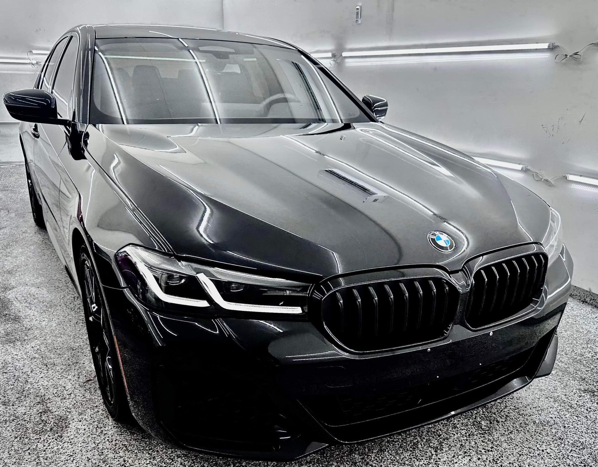 A black bmw is parked in a garage.