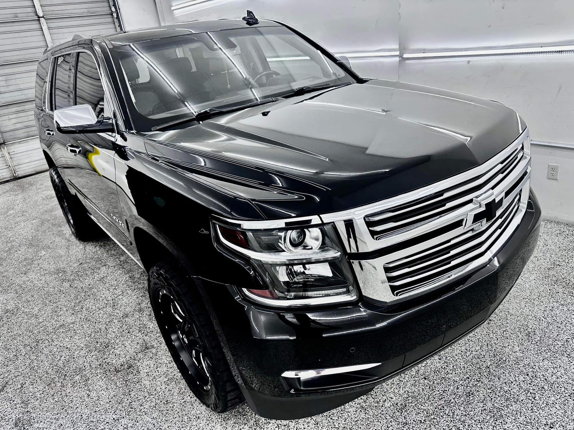 A black suv is parked in a garage.