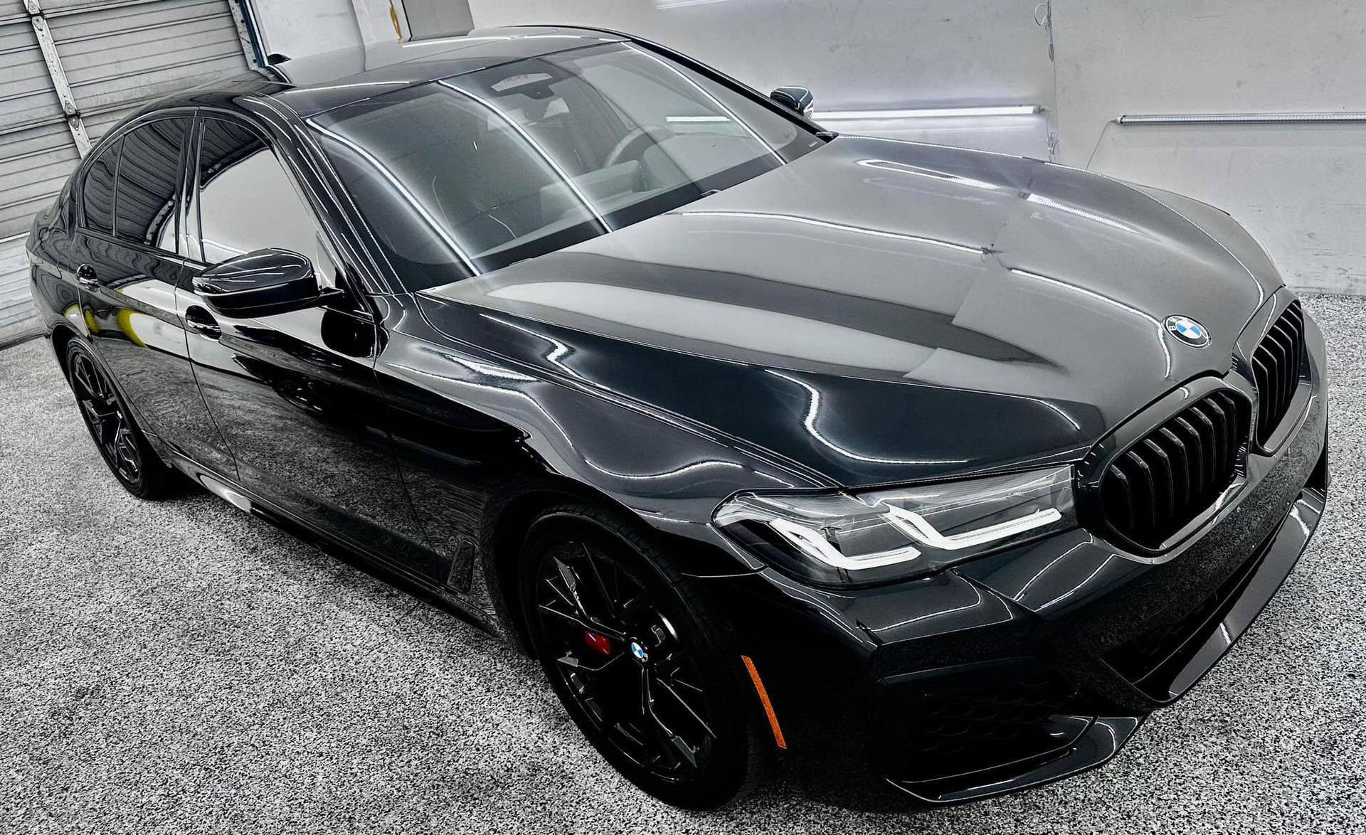 A black bmw is parked in a garage.