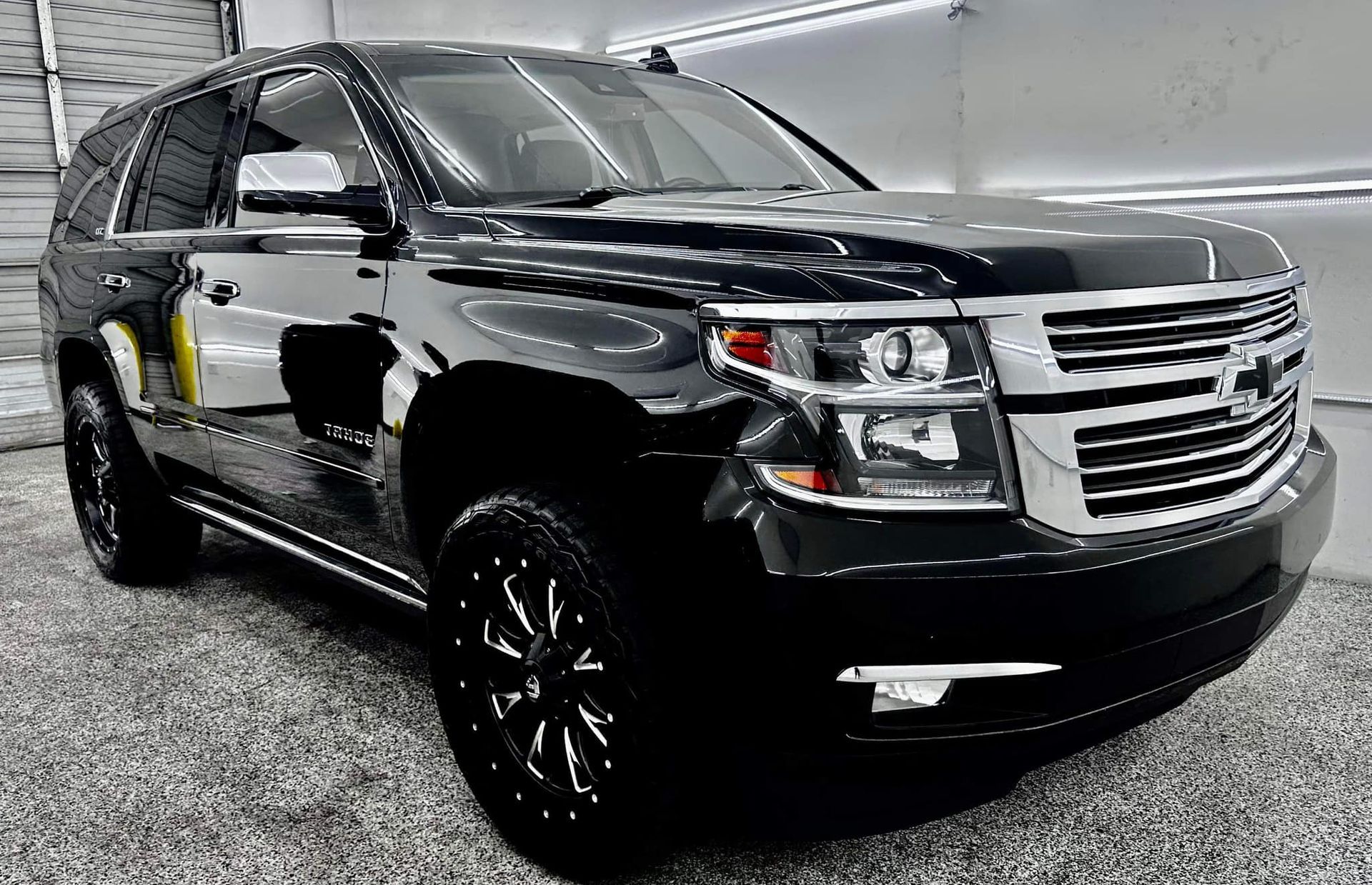 A black suv is parked in a garage.