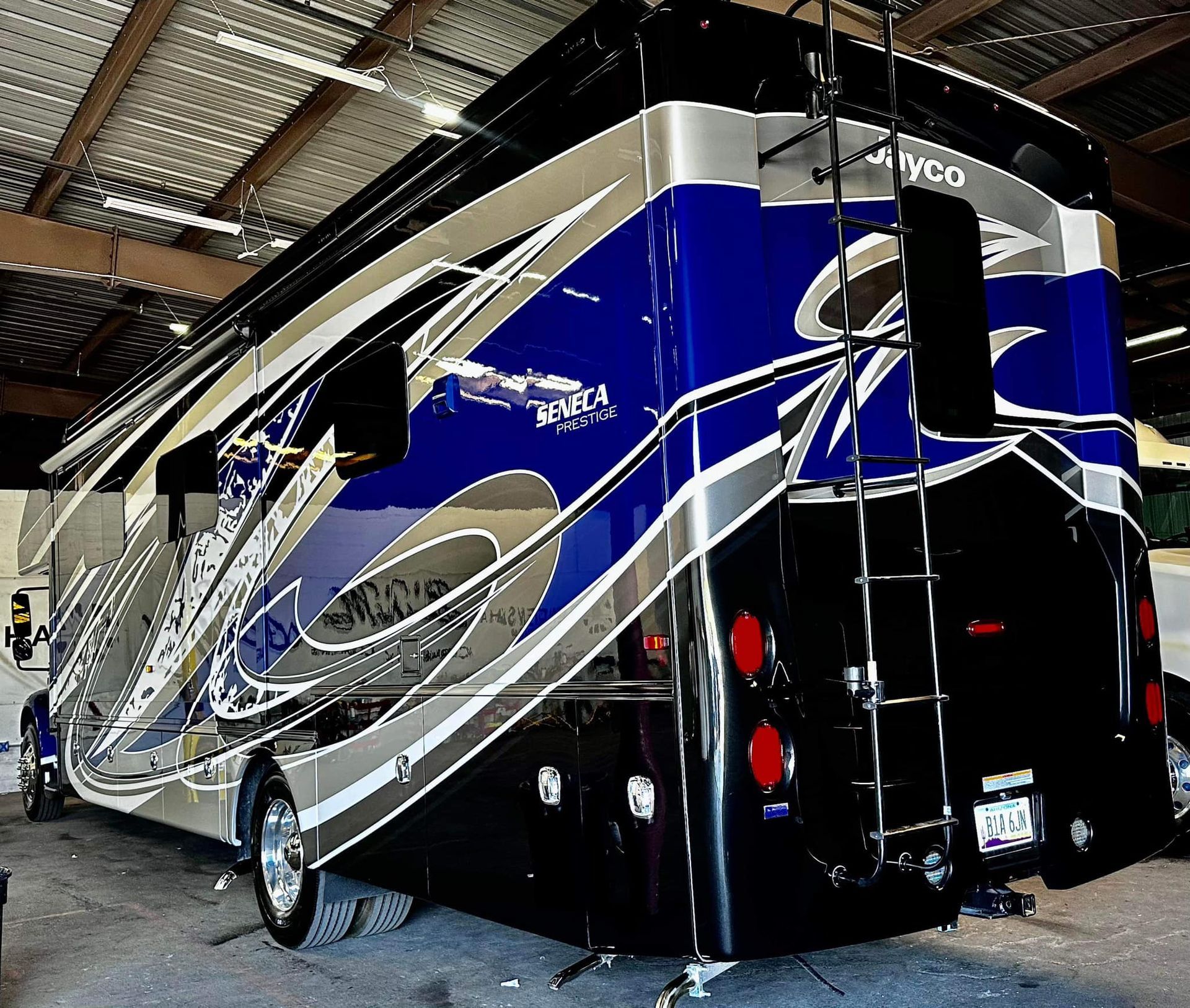 A blue and silver rv is parked in a garage with Bob Moses ceramic coating, Sensha World Crystal Glow