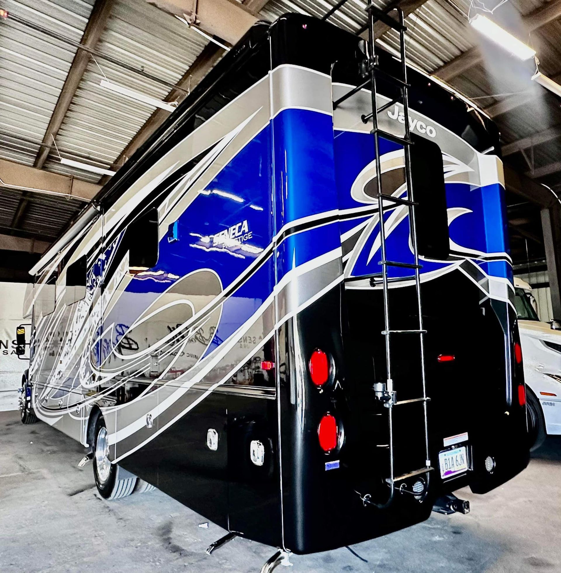 A blue and black jeep is parked in a garage with Bob Moses ceramic coating, Sensha World Crystal Glow
