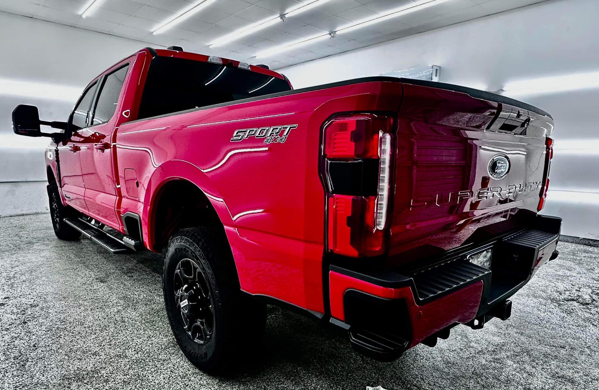 A red pickup truck is parked in a garage.