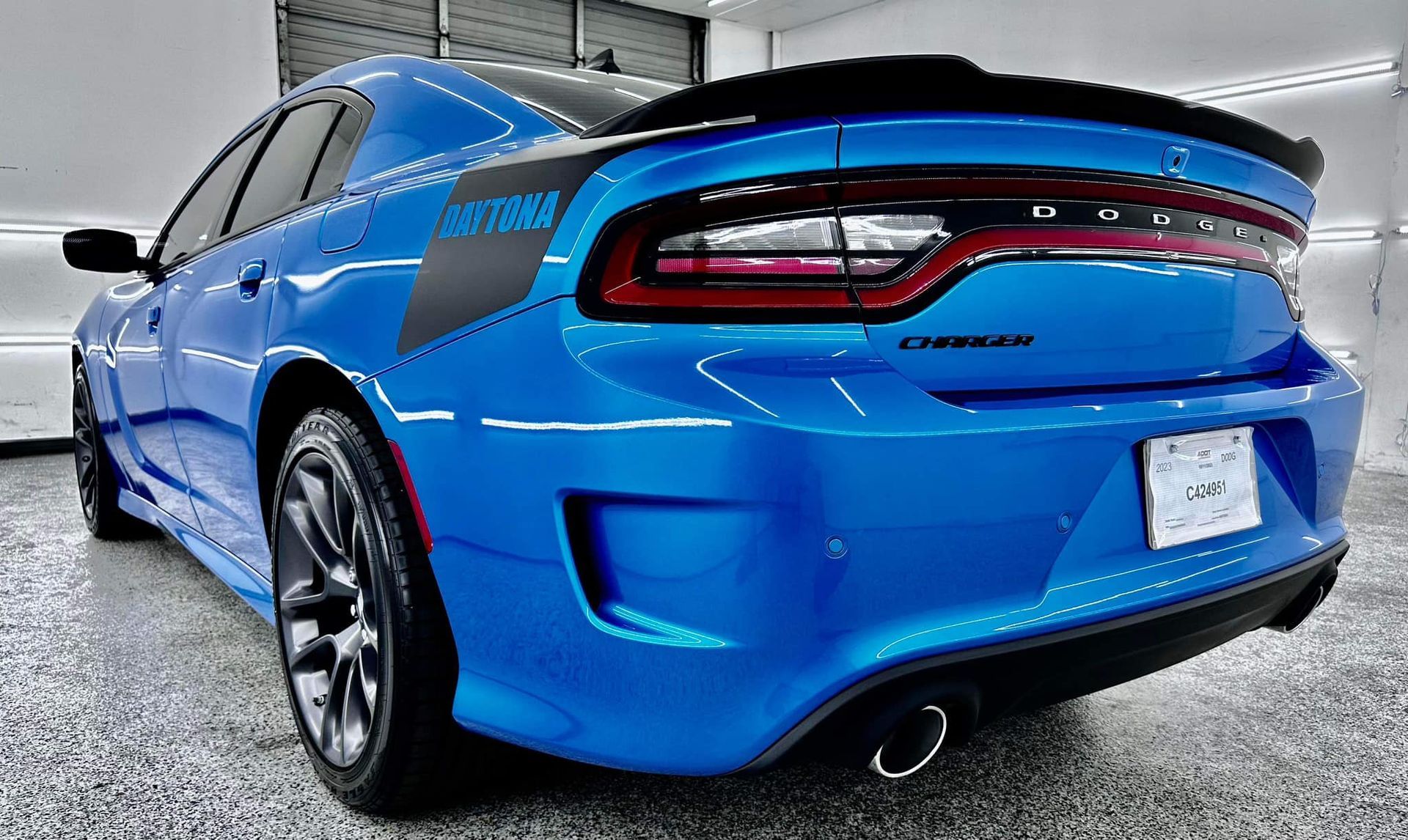 A blue dodge charger is parked in a garage.