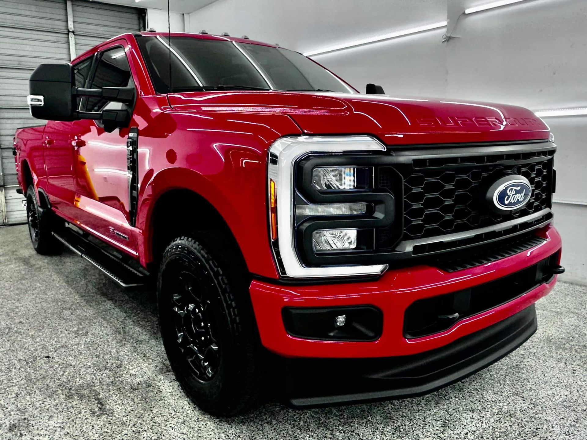 A red ford truck is parked in a garage.