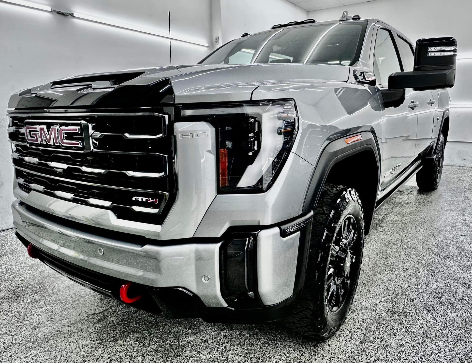 A silver gmc truck is parked in a garage.