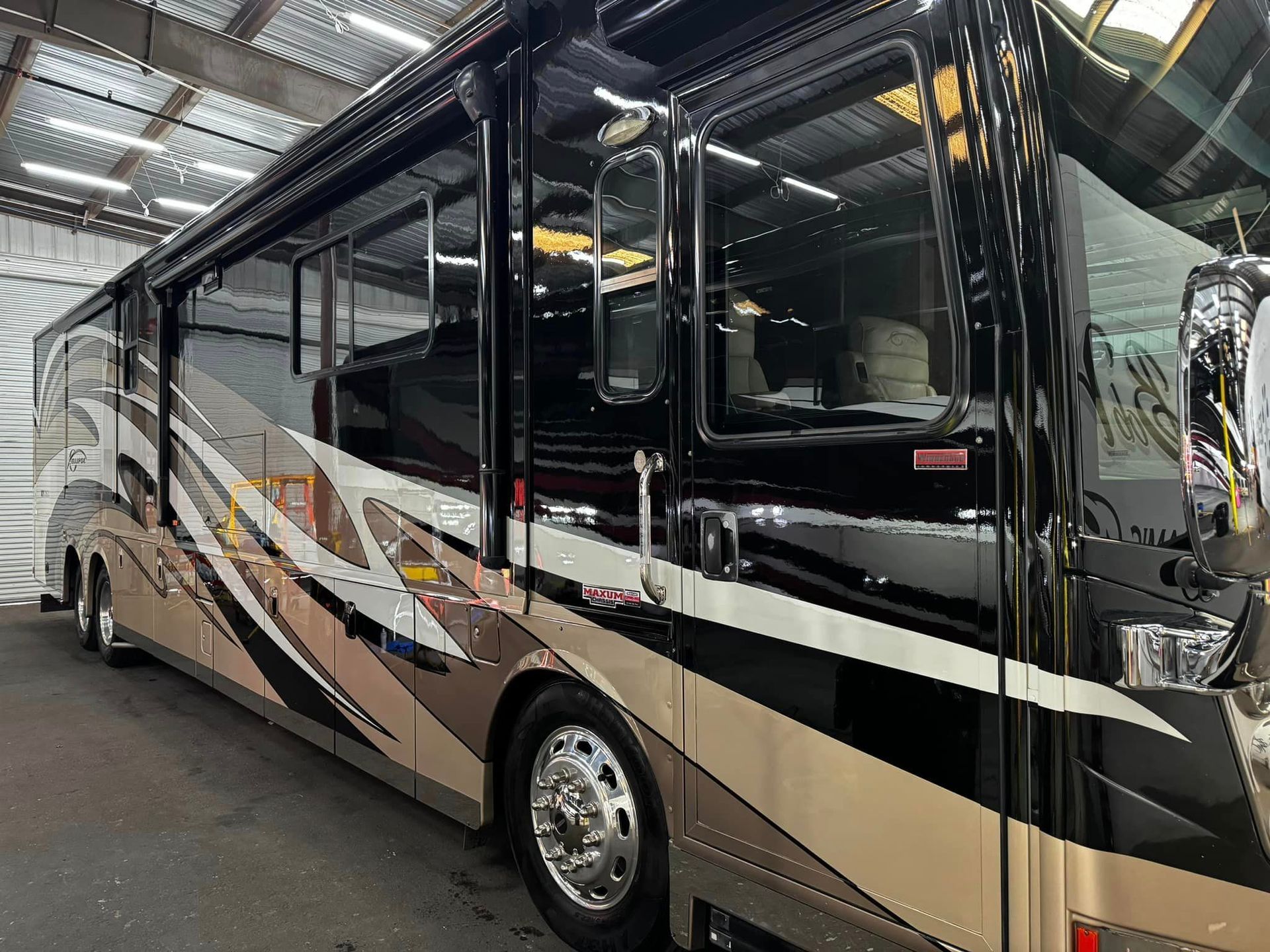 A large rv is parked in a warehouse with Bob Moses ceramic coating, Sensha World Crystal Glow