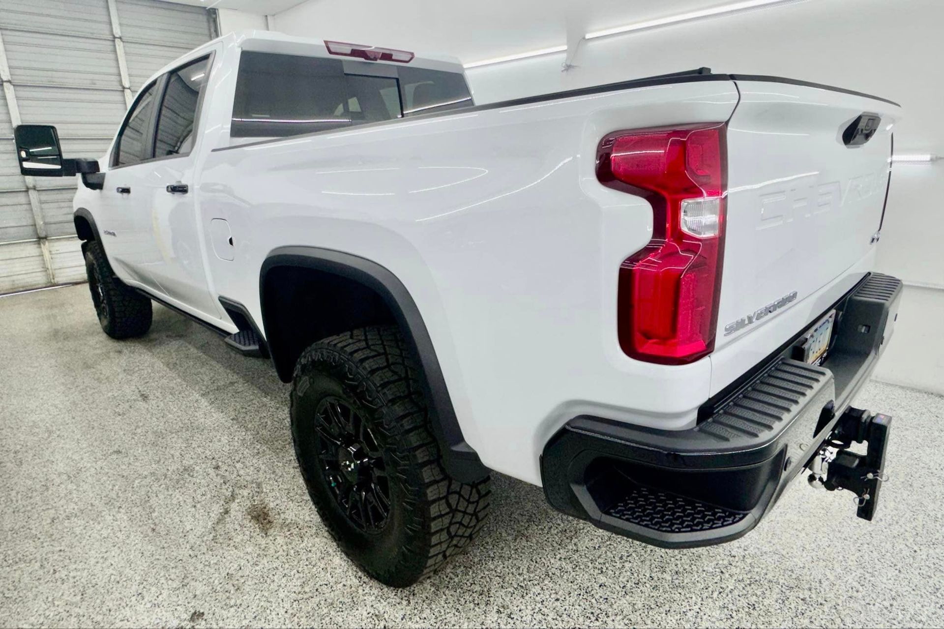 A white pickup truck is parked in a garage.