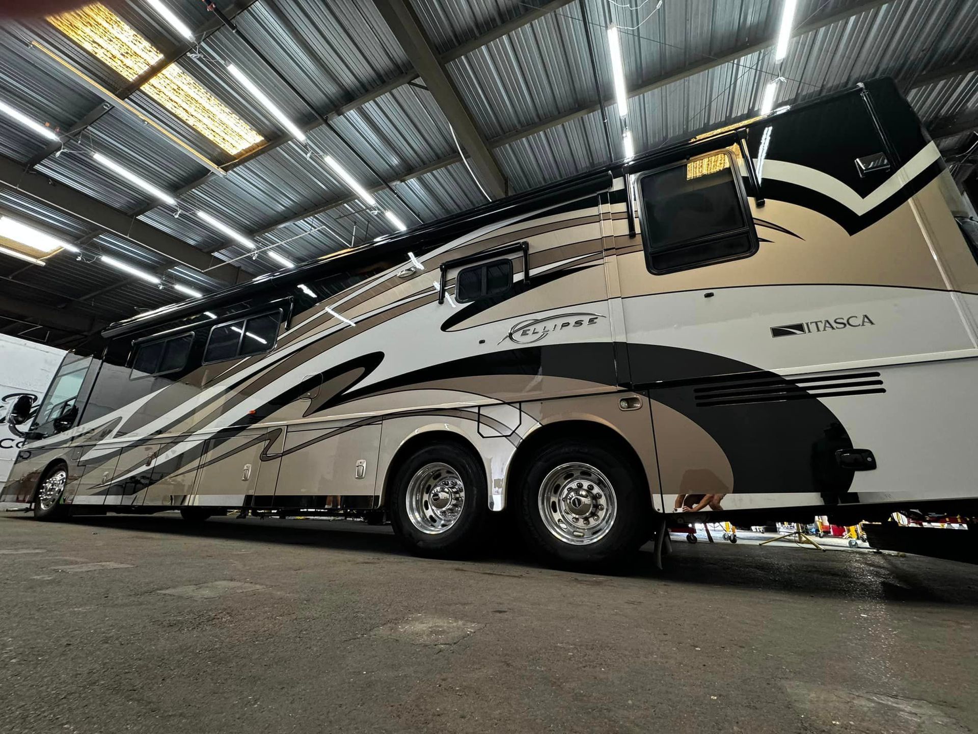 A large rv is parked in a warehouse with Bob Moses ceramic coating, Sensha World Crystal Glow