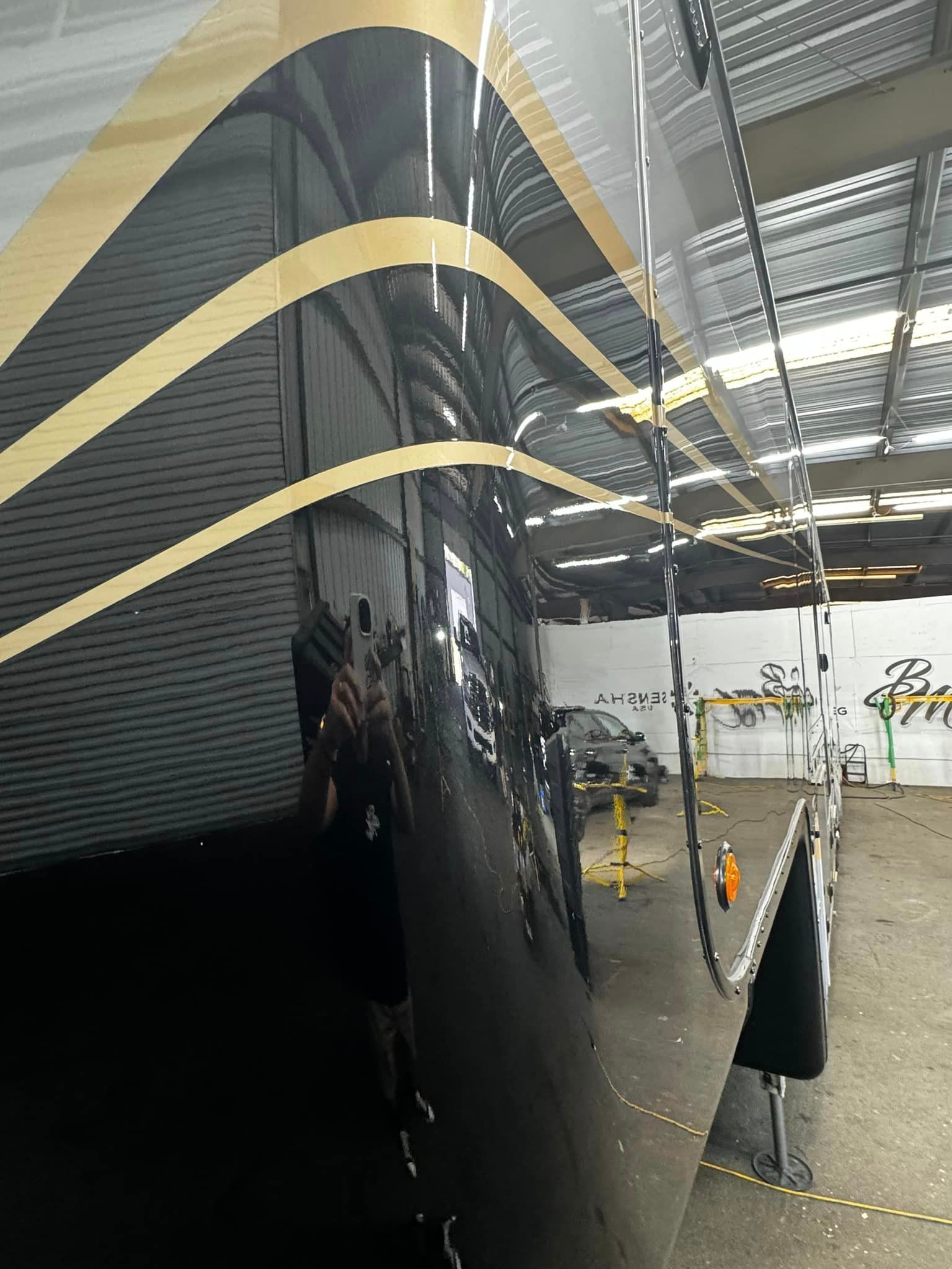 A black and gold boat is sitting in a warehouse with Bob Moses ceramic coating, Sensha World Crystal Glow