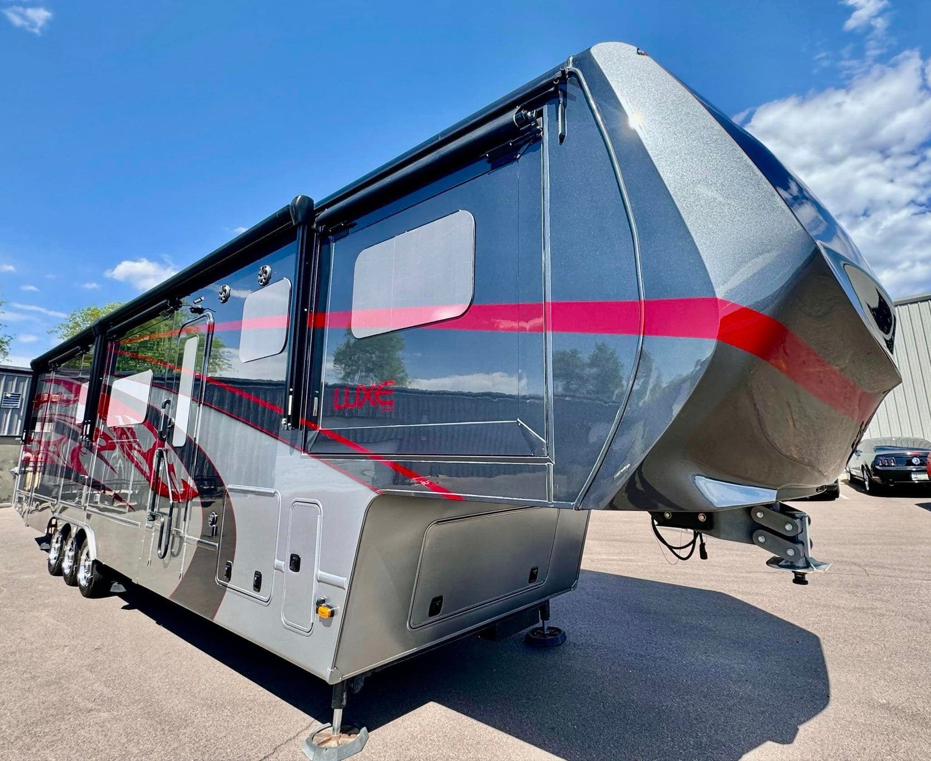 A silver and red trailer is parked in a parking lot with Bob Moses ceramic coating, Sensha World Crystal Glow