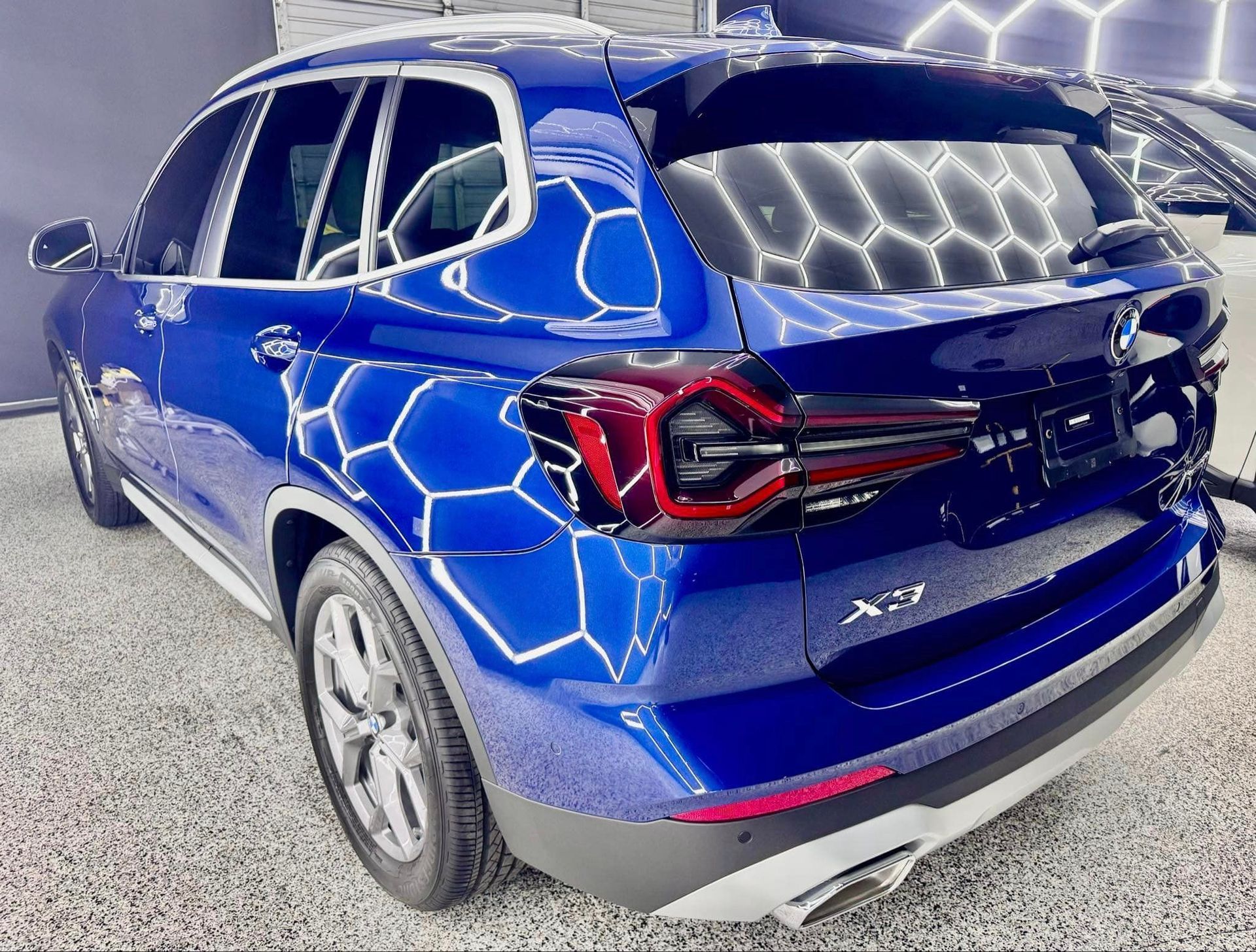 A blue bmw x3 is parked in a parking lot