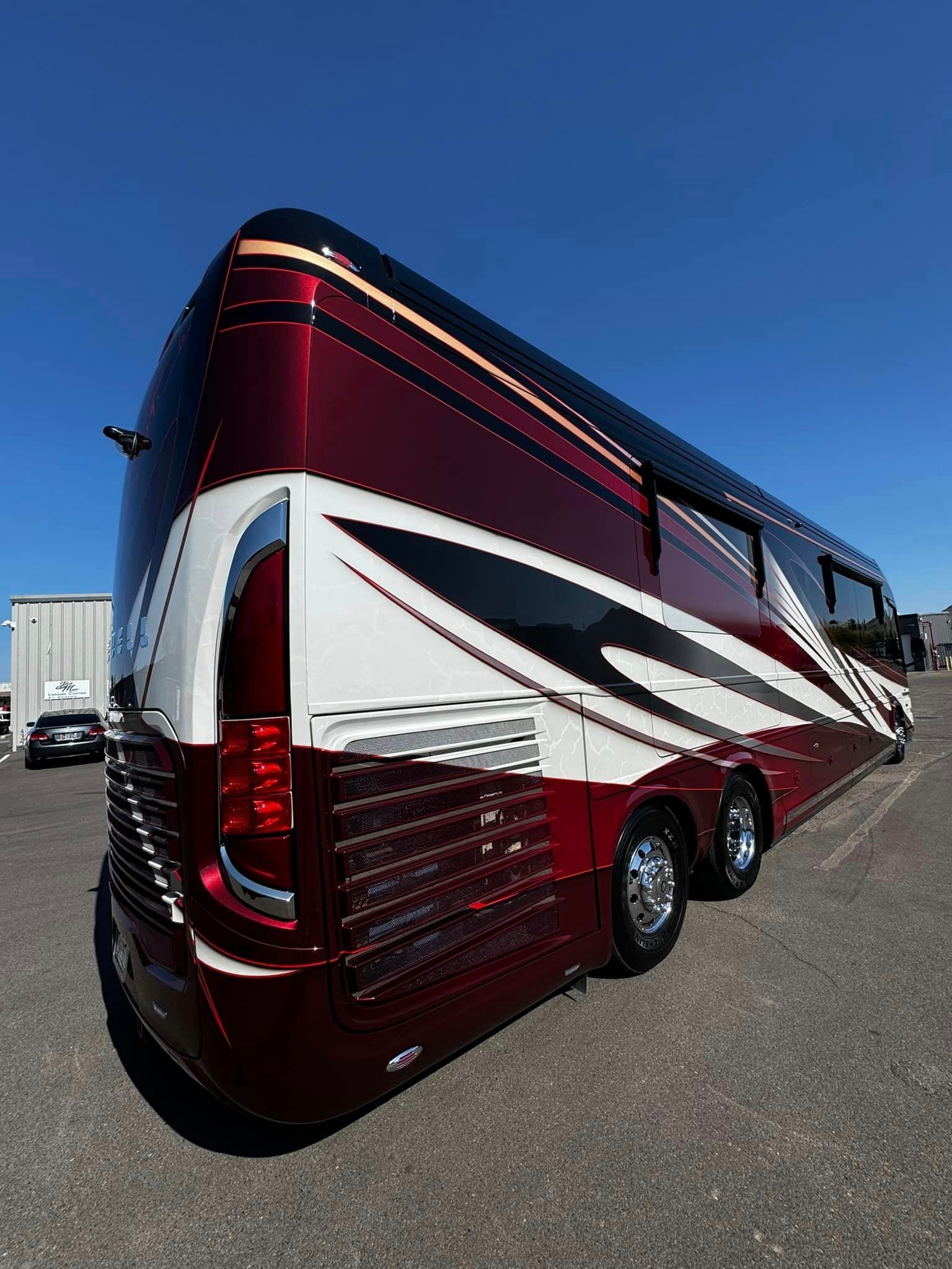 A red and white bus is parked in a parking lot with Bob Moses ceramic coating, Sensha World Crystal Glow