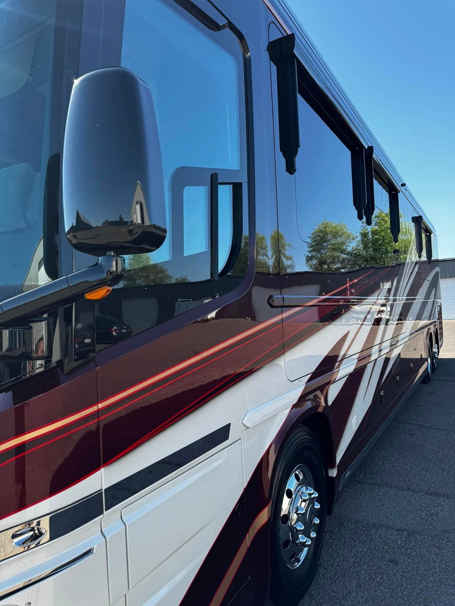 A red and white bus is parked on the side of the road with Bob Moses ceramic coating, Sensha World Crystal Glow