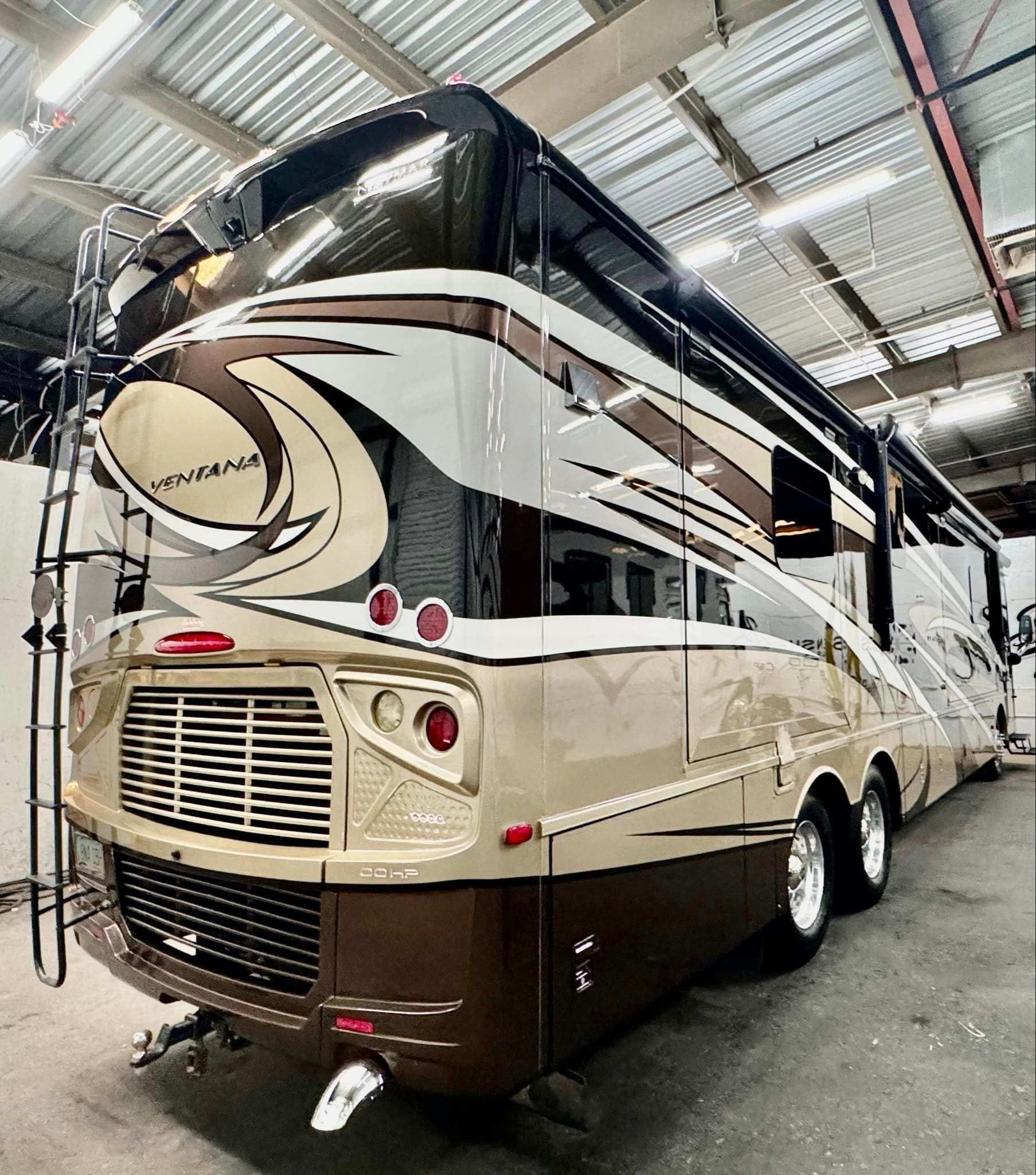 A large rv is parked in a warehouse with Bob Moses ceramic coating, Sensha World Crystal Glow