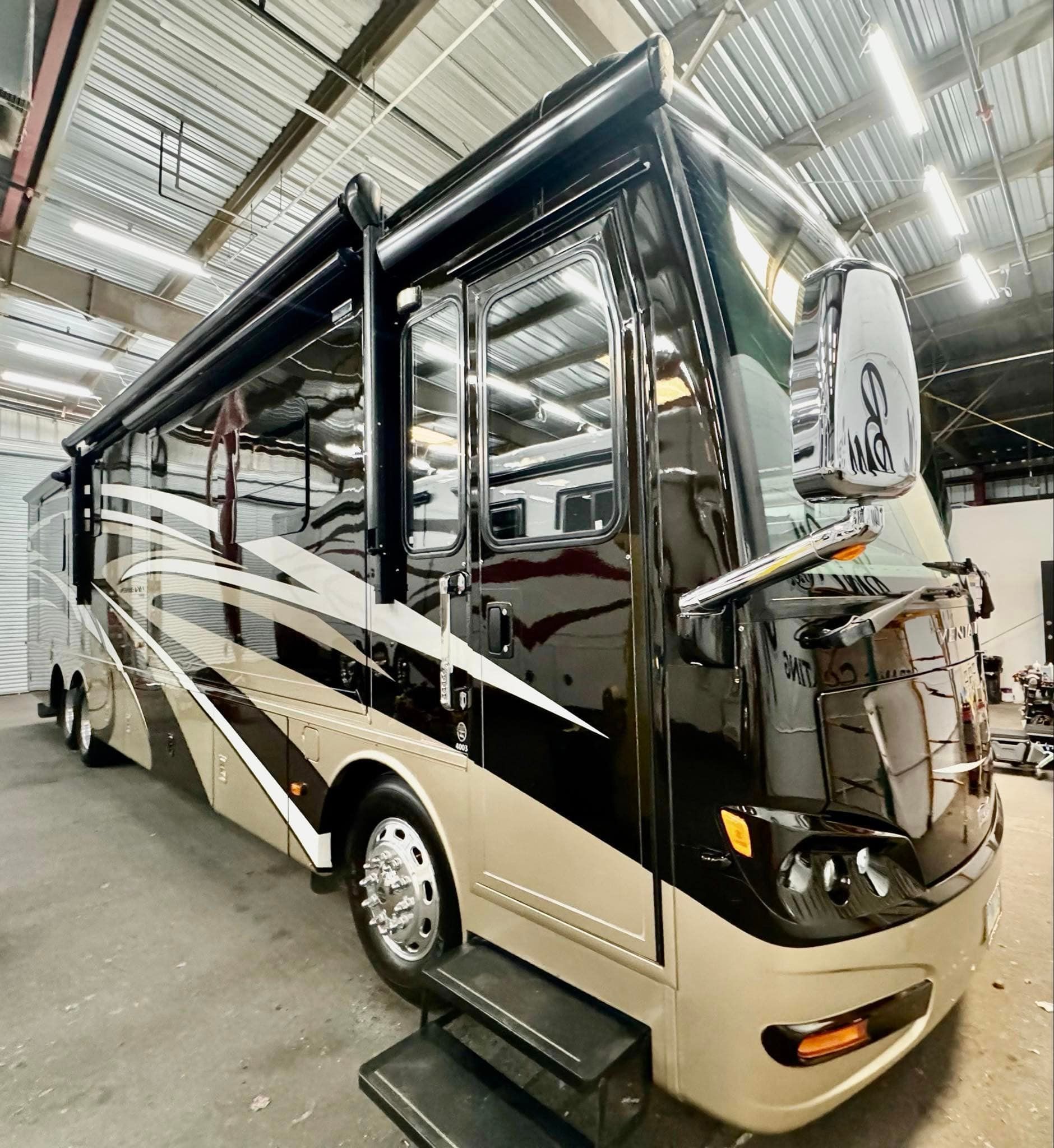A large rv is parked in a warehouse with Bob Moses ceramic coating, Sensha World Crystal Glow