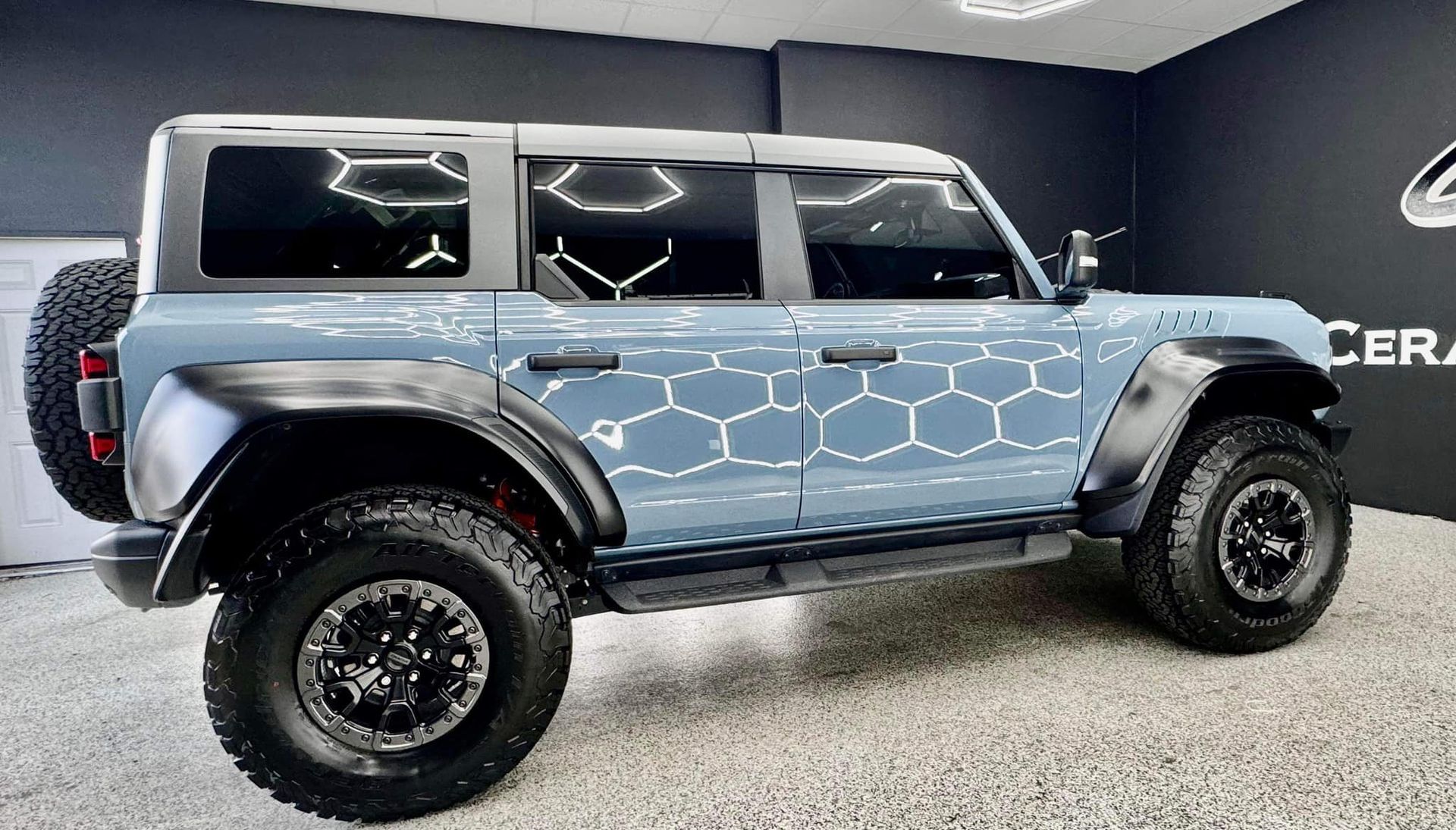 A blue ford bronco is parked in a garage.