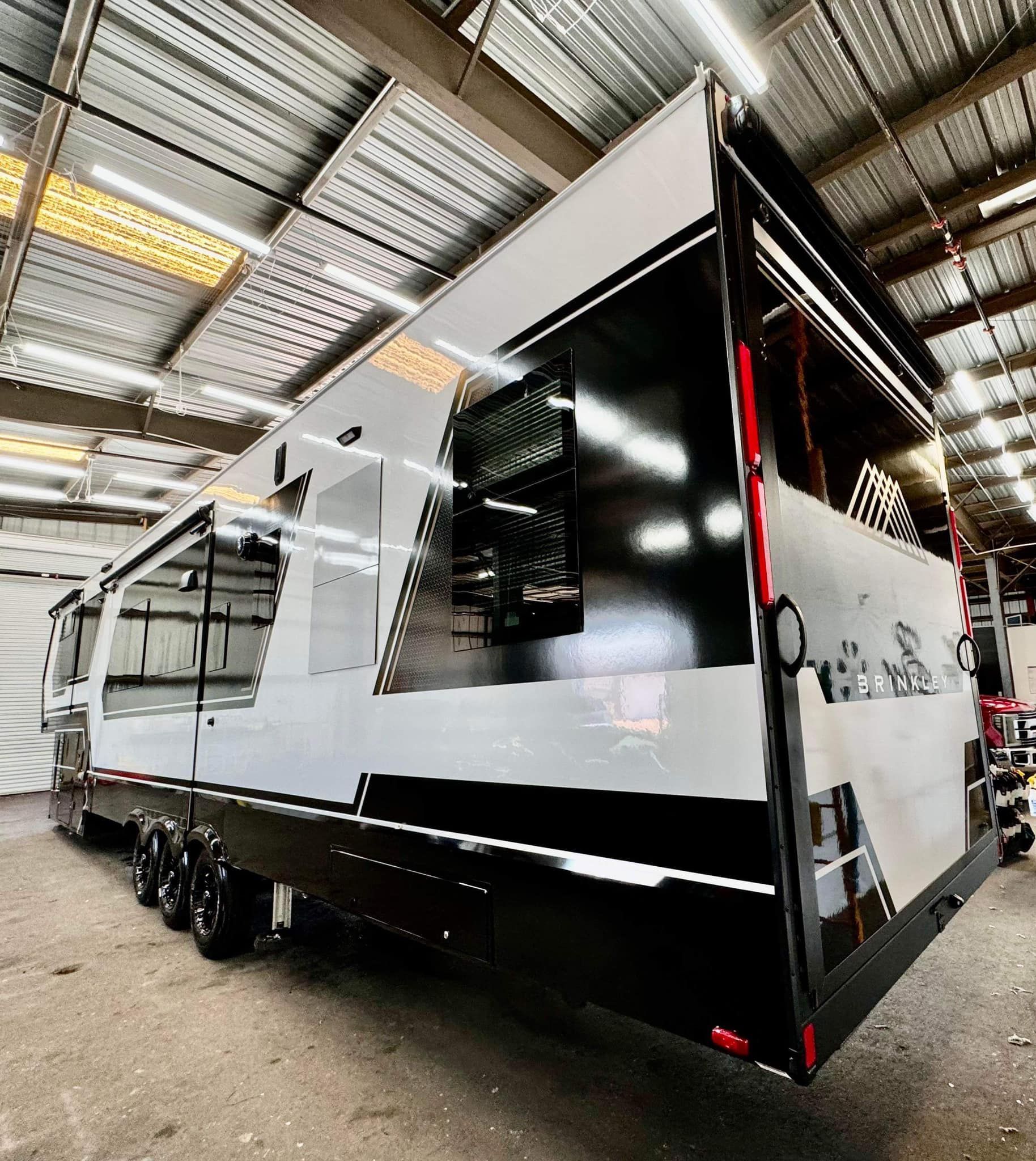 A black and white trailer is parked in a warehouse with Bob Moses ceramic coating, Sensha World Crystal Glow