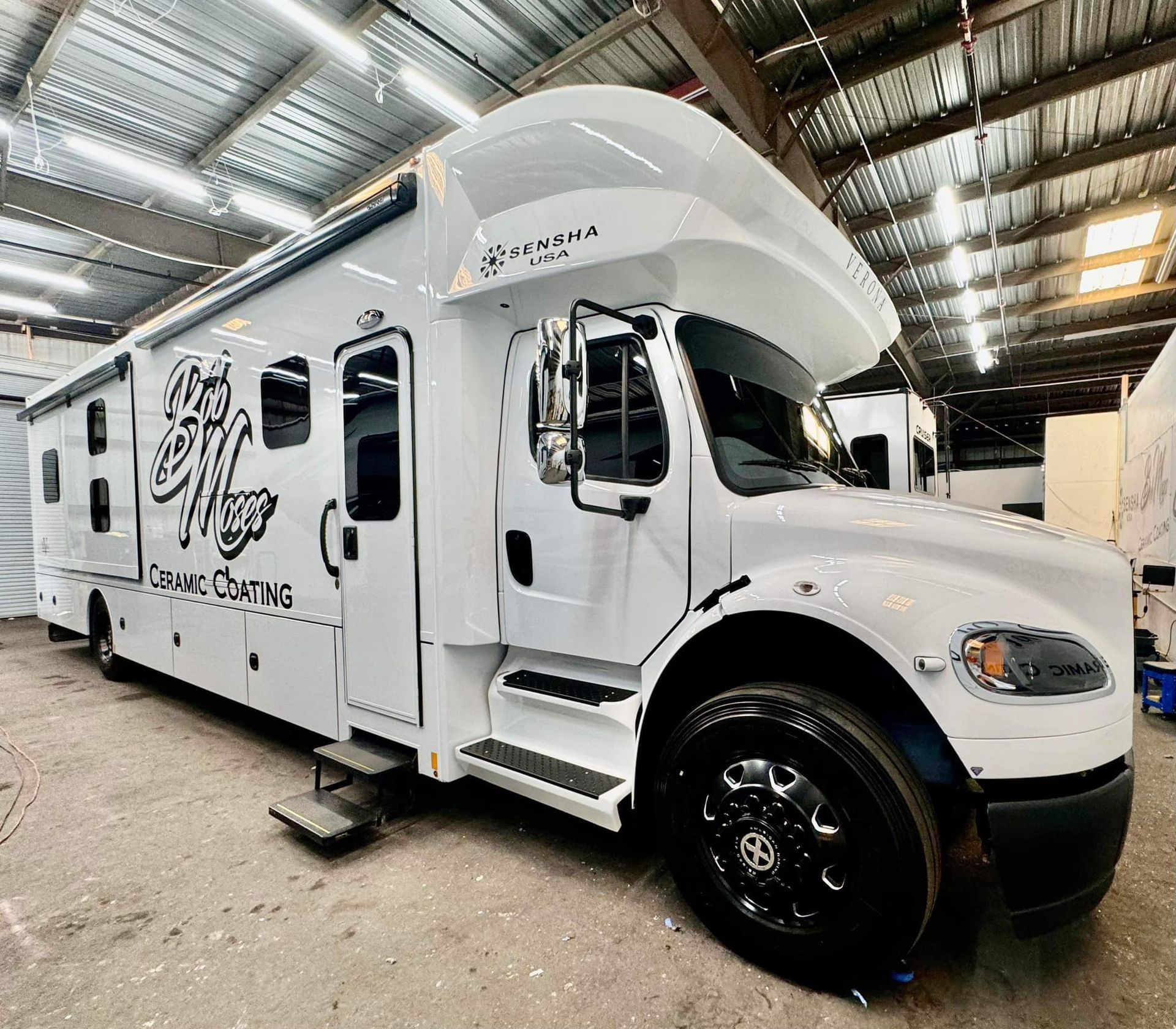 A large white truck is parked in a warehouse.