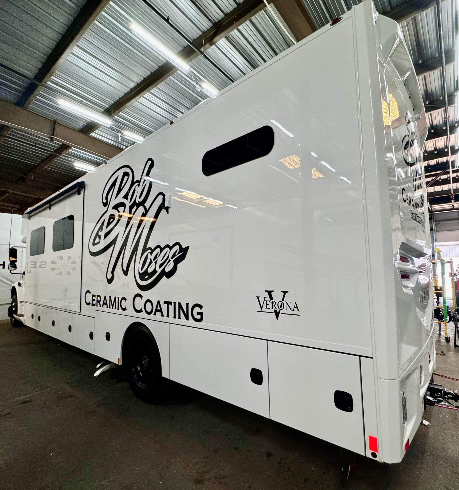 A white bus with the word ceramic coating on the side