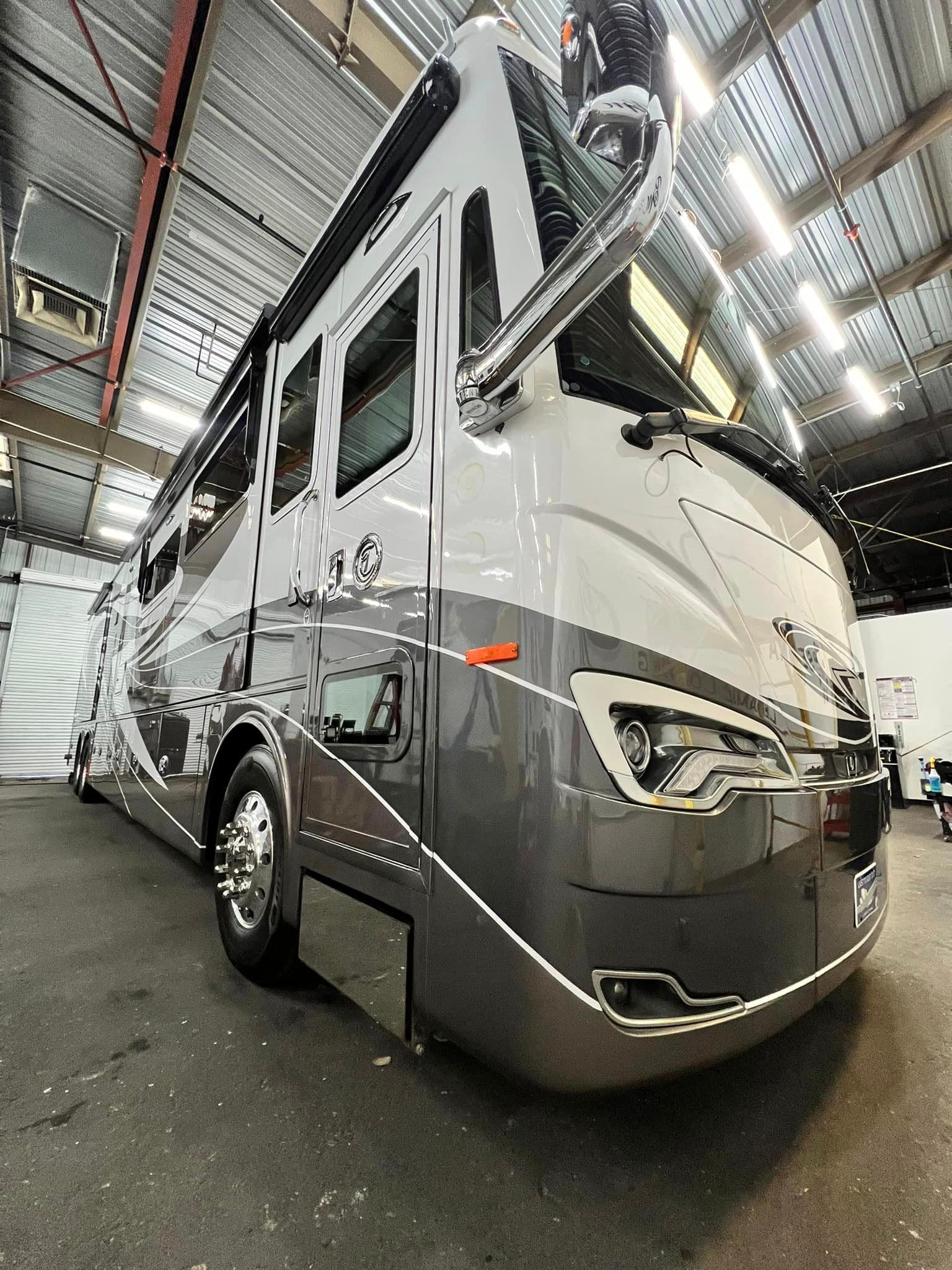 A large rv is parked in a warehouse with Bob Moses ceramic coating, Sensha World Crystal Glow