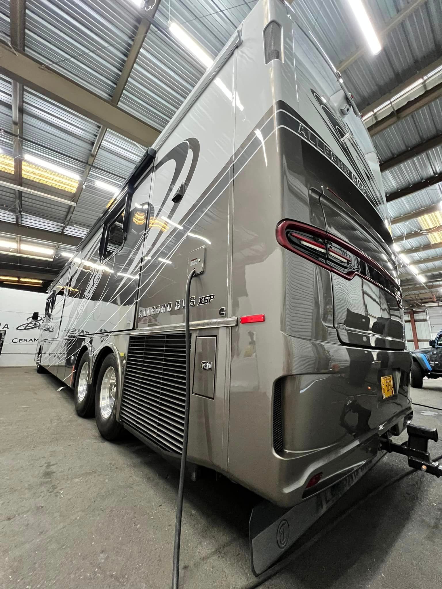 A large rv is parked in a warehouse with Bob Moses ceramic coating, Sensha World Crystal Glow