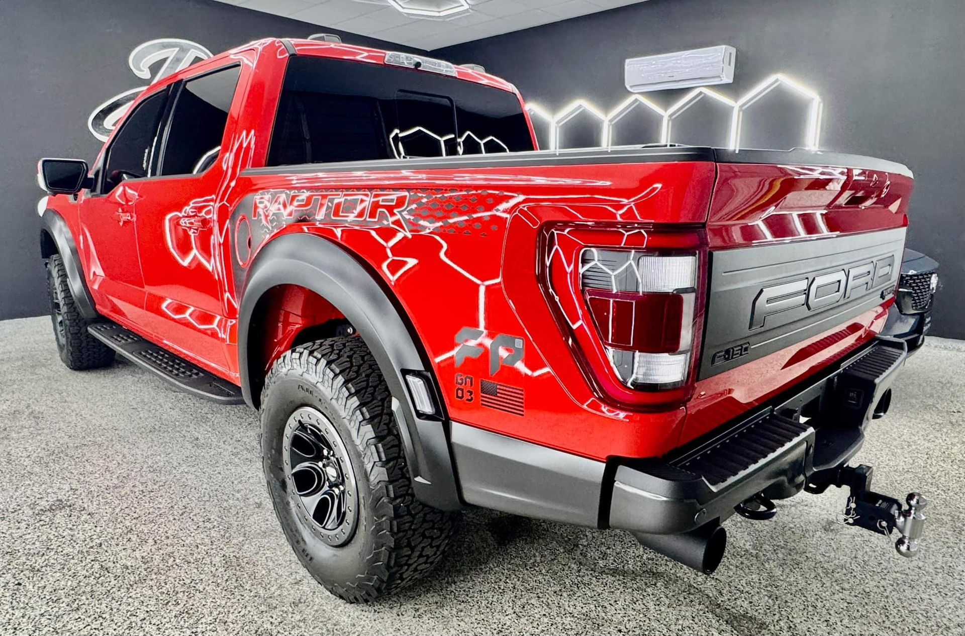 A red ford raptor truck is parked in a showroom with Bob Moses ceramic coating, Sensha World Crystal Glow