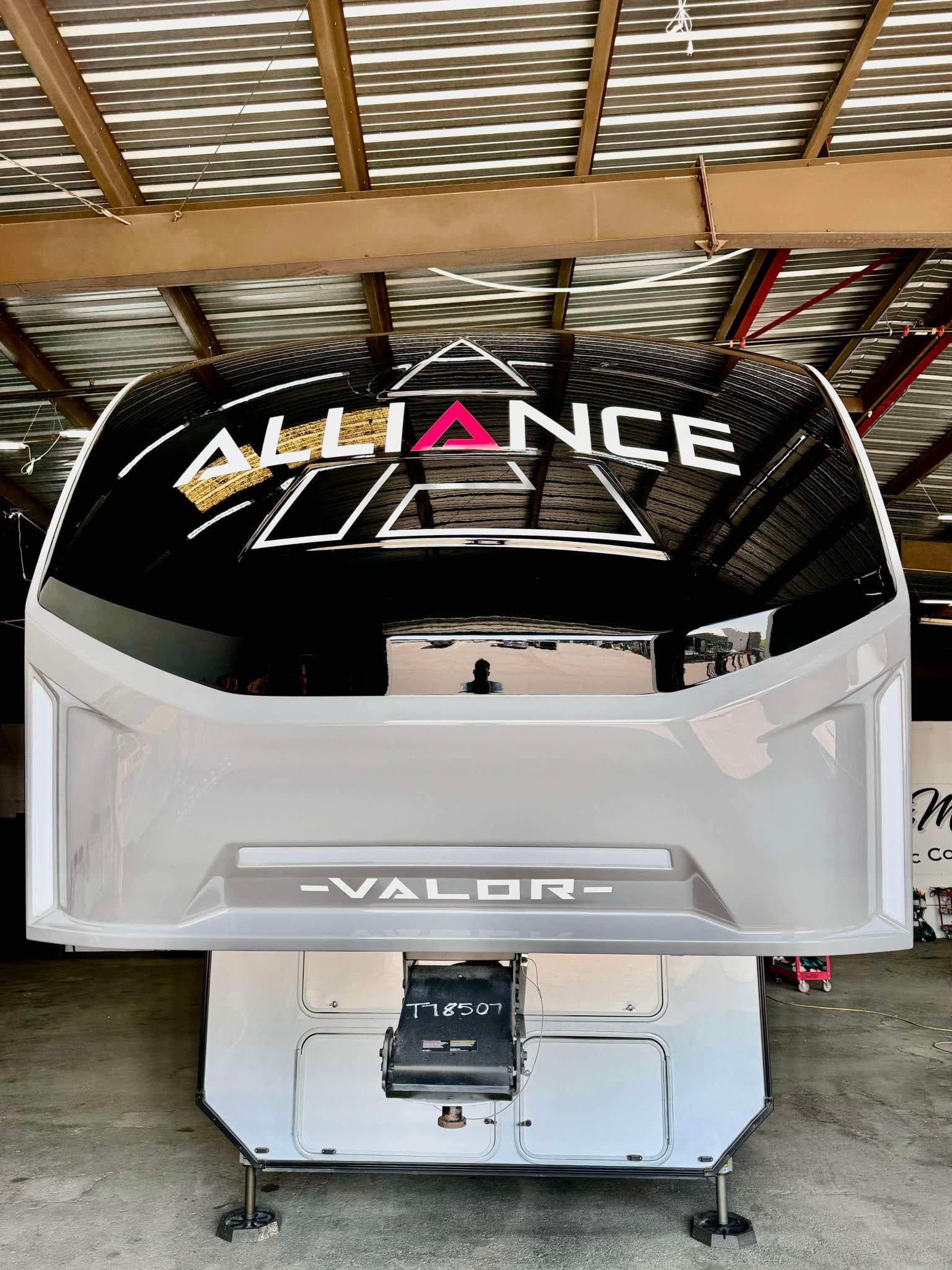 A boat is sitting under a roof in a warehouse.
