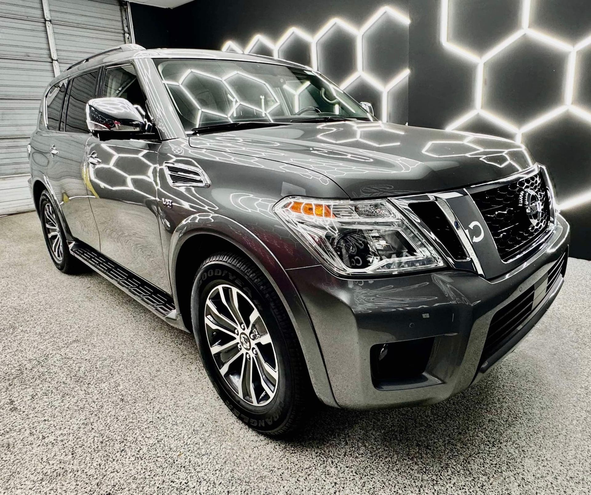 A gray nissan patrol is parked in front of a building with Bob Moses ceramic coating, Sensha World Crystal Glow
