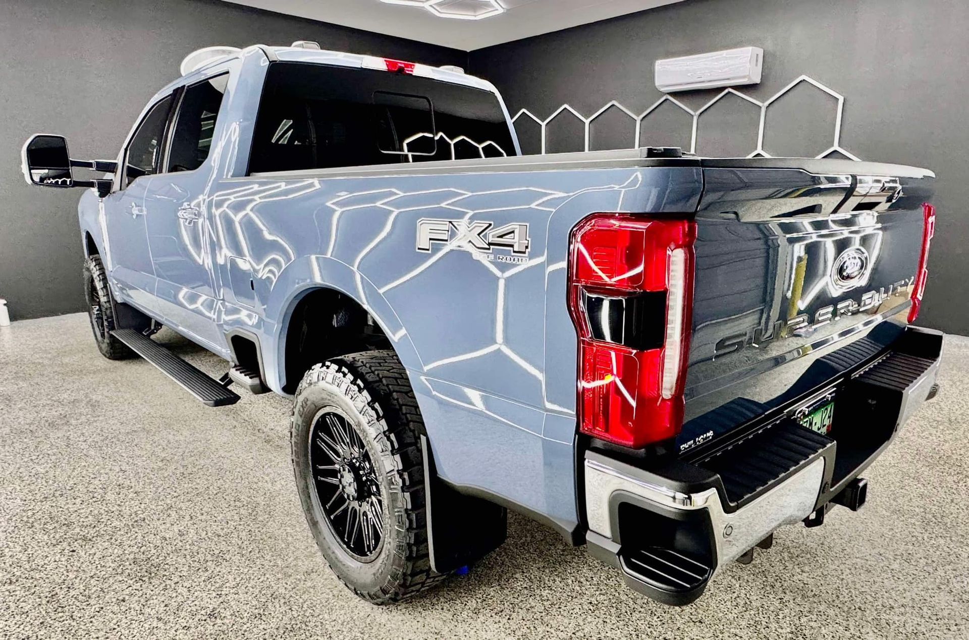 A gray pickup truck is parked in a garage with Bob Moses ceramic coating, Sensha World Crystal Glow