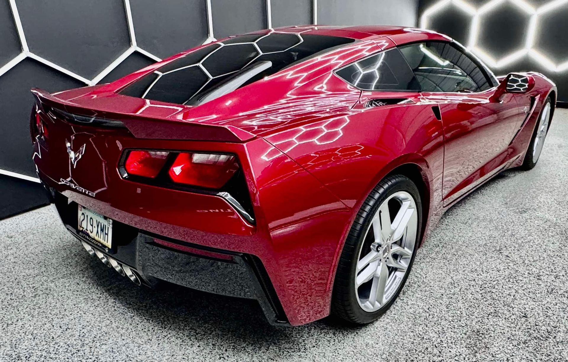 A red sports car is parked in a garage with Bob Moses ceramic coating, Sensha World Crystal Glow