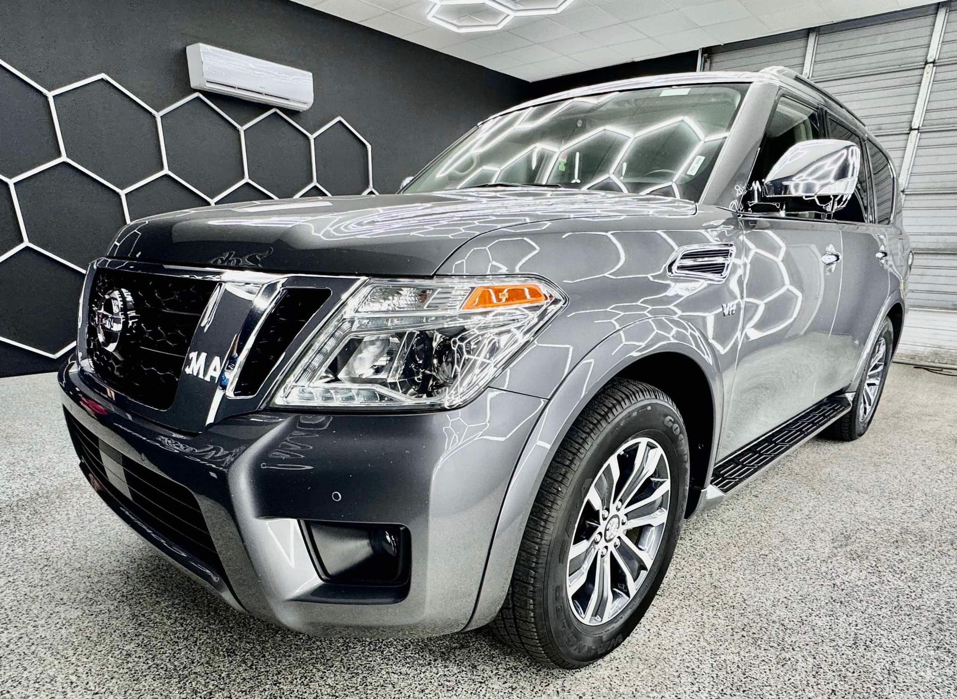 A gray nissan patrol is parked in a garage with Bob Moses ceramic coating, Sensha World Crystal Glow