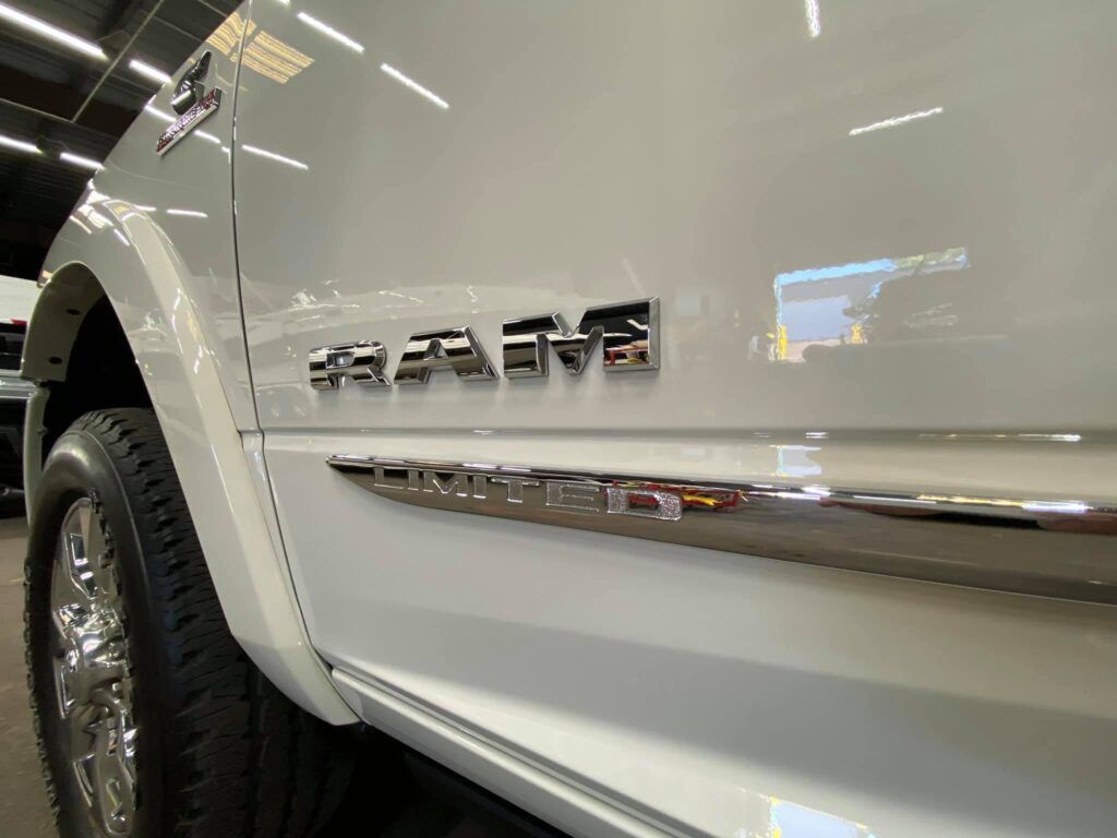 A white ram truck is parked in a showroom with Bob Moses ceramic coating, Sensha World Crystal Glow