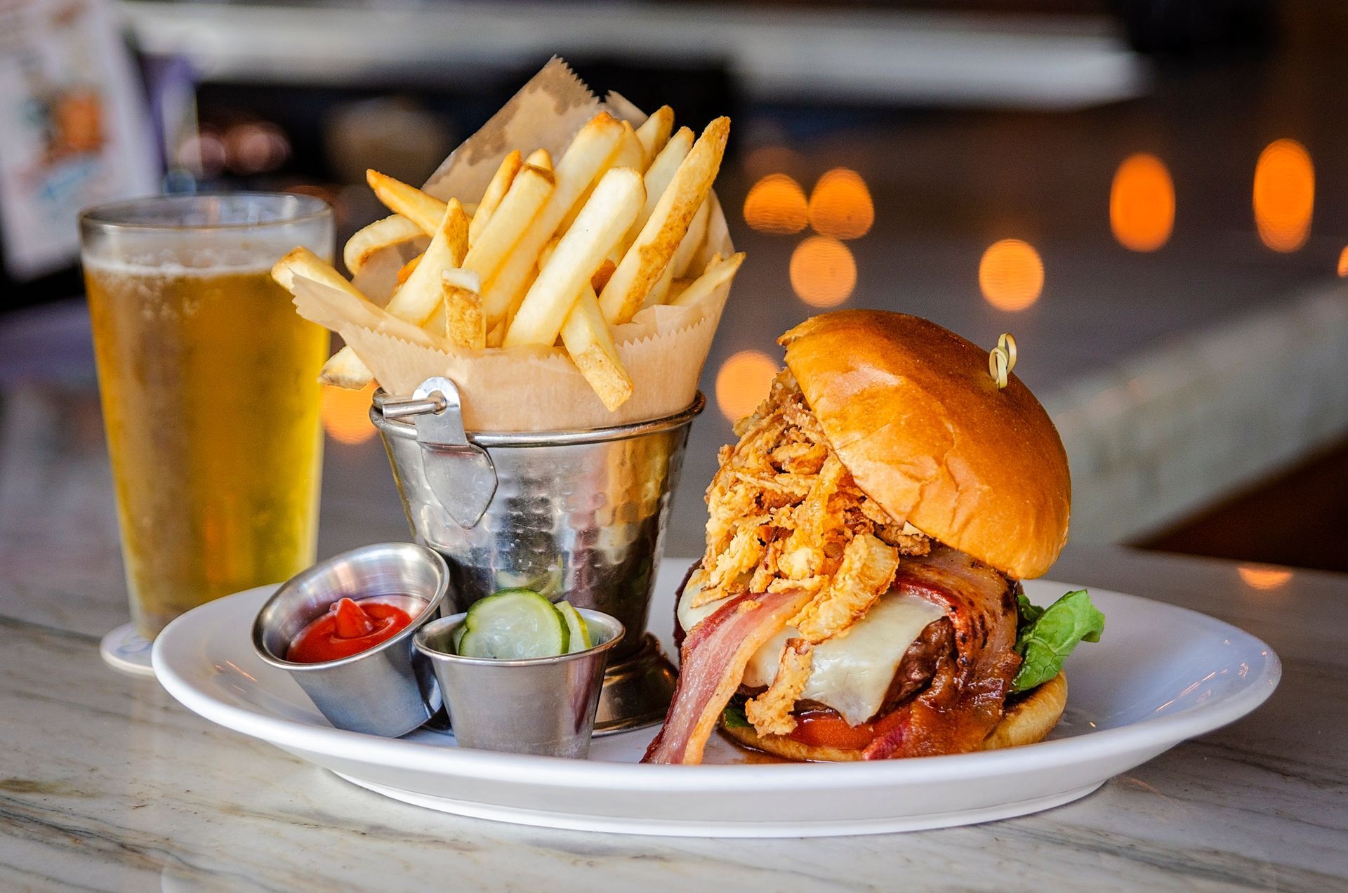 A plate of food with a hamburger and french fries on a table.