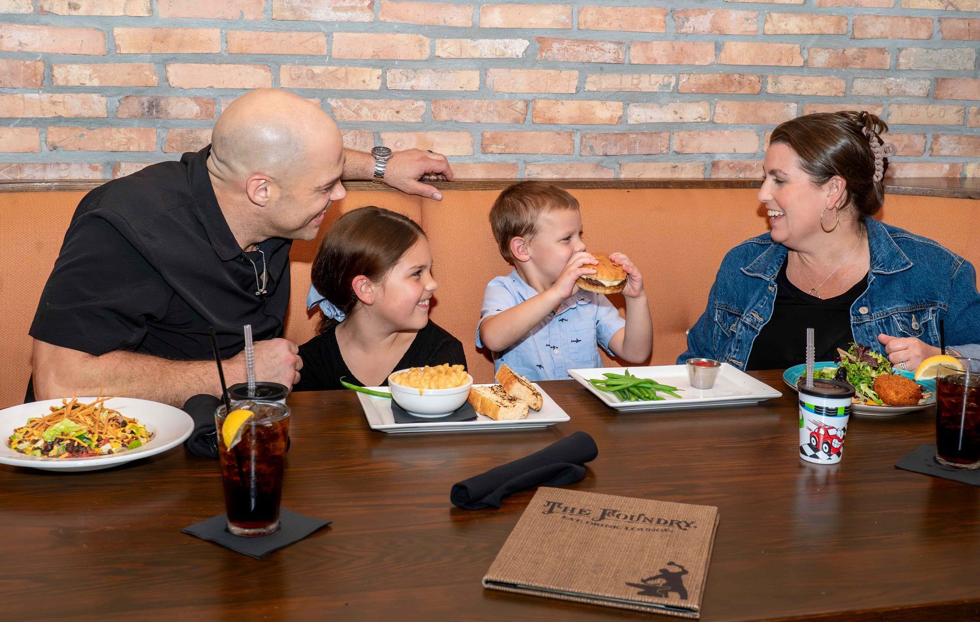 A family is sitting at a table in a restaurant eating food.